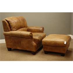  Wide seat traditional shaped armchair and matching footstool upholstered in tan leather  