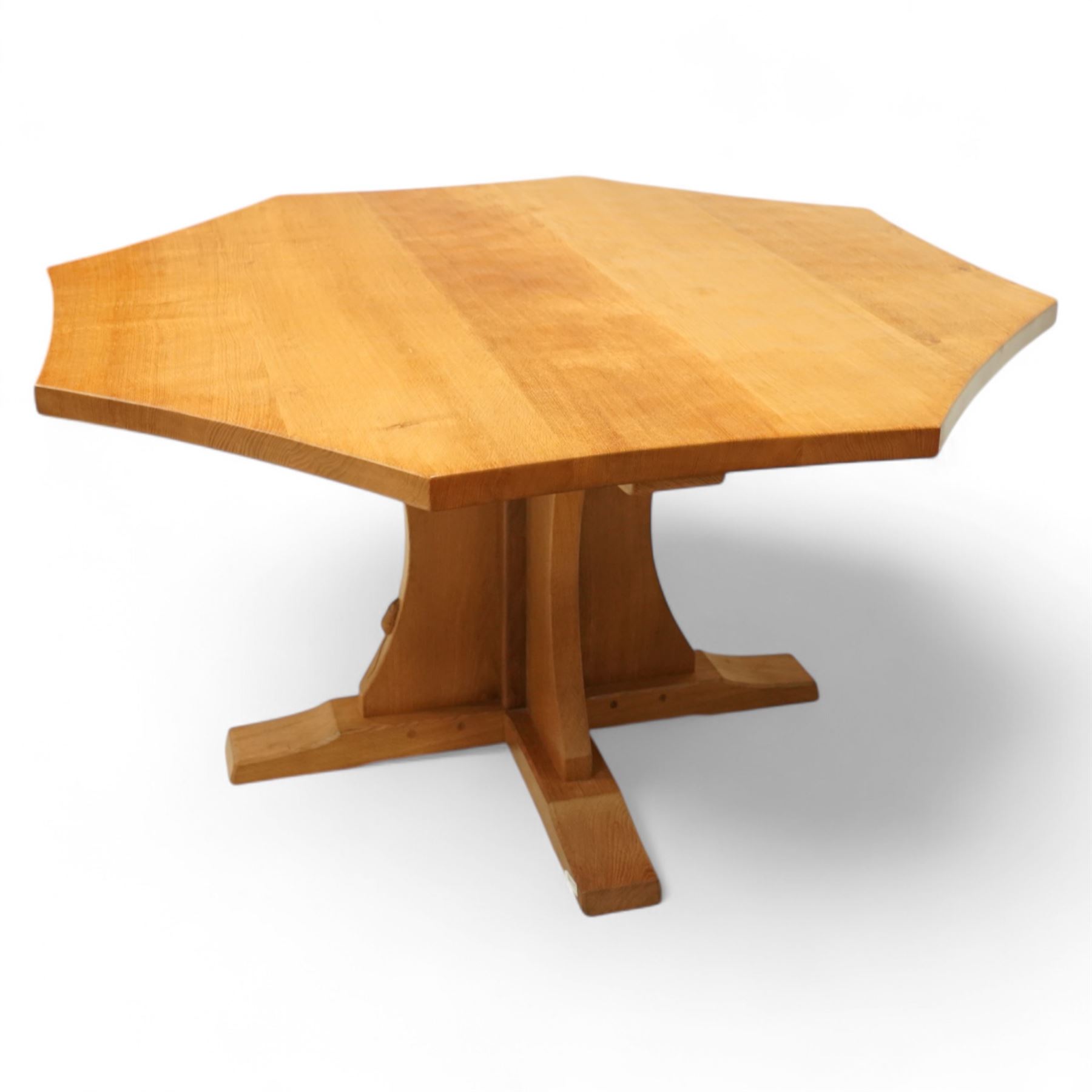 Mouseman - adzed oak octagonal concave dining table, raised on cruciform base, the supports and sledge feet also adzed, carved with fat mouse signature, by the workshop of Robert Thompson, Kilburn