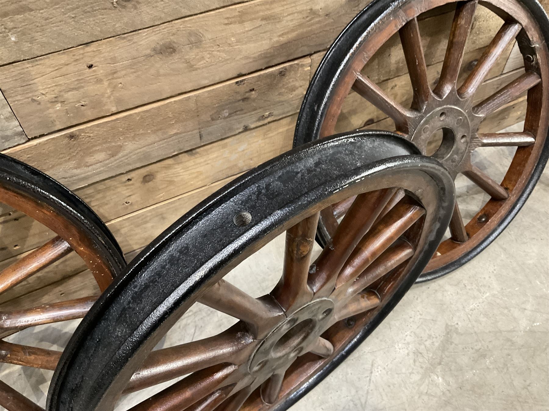 Set of four wheels from an early 20th century cart, wood with metal outer