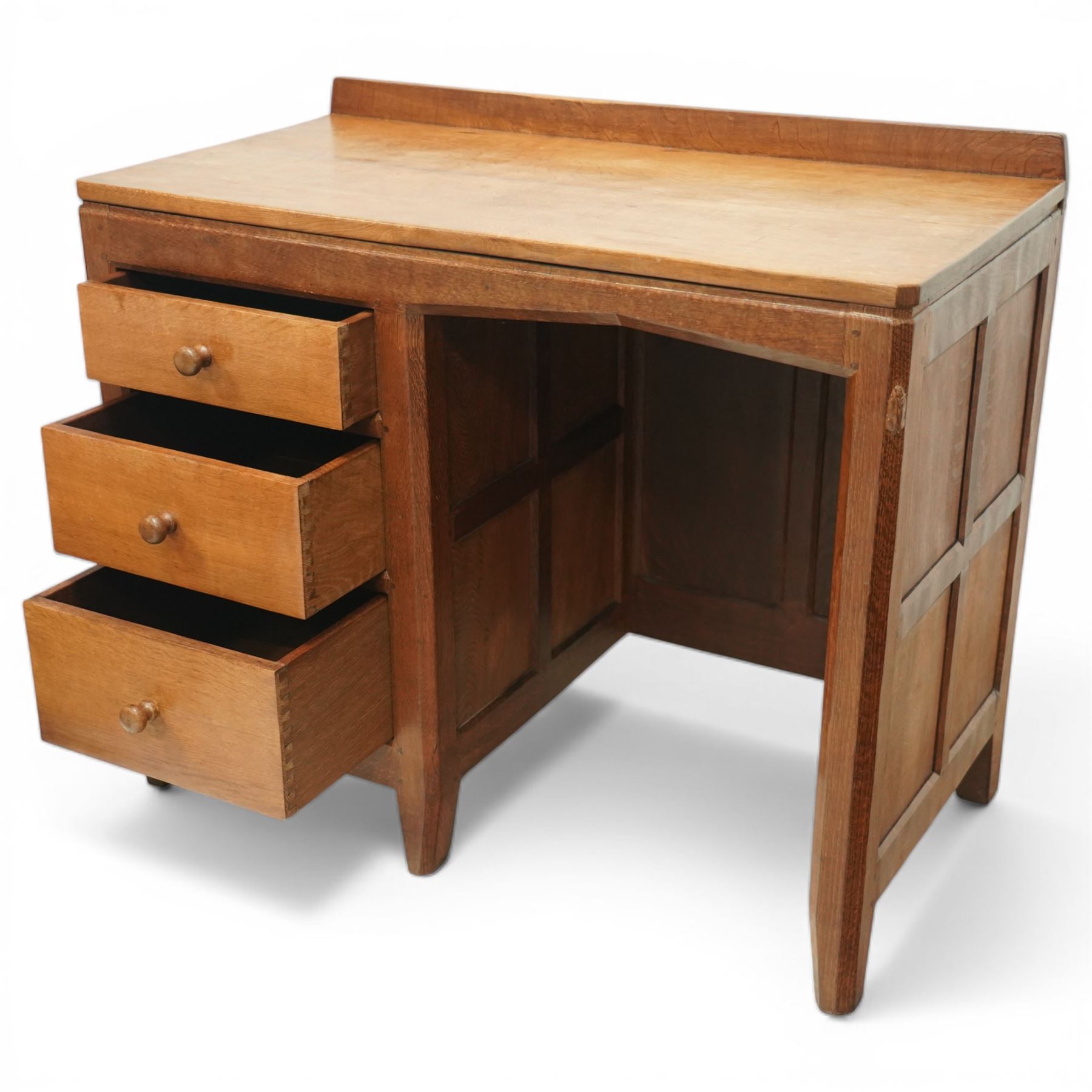 Rabbitman - oak single pedestal desk, adzed top with galleried back, with three graduating drawers with turned wooden knobs, enclosed kneehole with adzed detailing throughout the panelling and supports, with carved rabbit signature, by Peter Heap of Wetwang