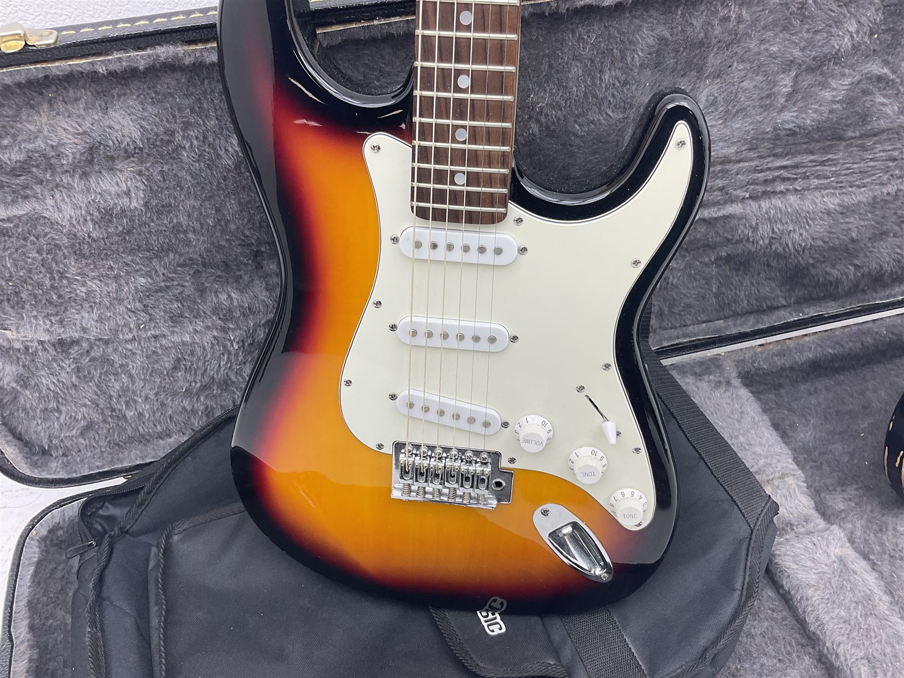 Fender style sunburst electric guitar with manuscript mark 'Zenta Stratocaster 1963' L97cm; in hard carrying case; another similar unmarked sunburst electric guitar; in gig bag; and Fender Frontman Amplifier, serial no.M473406 (3)