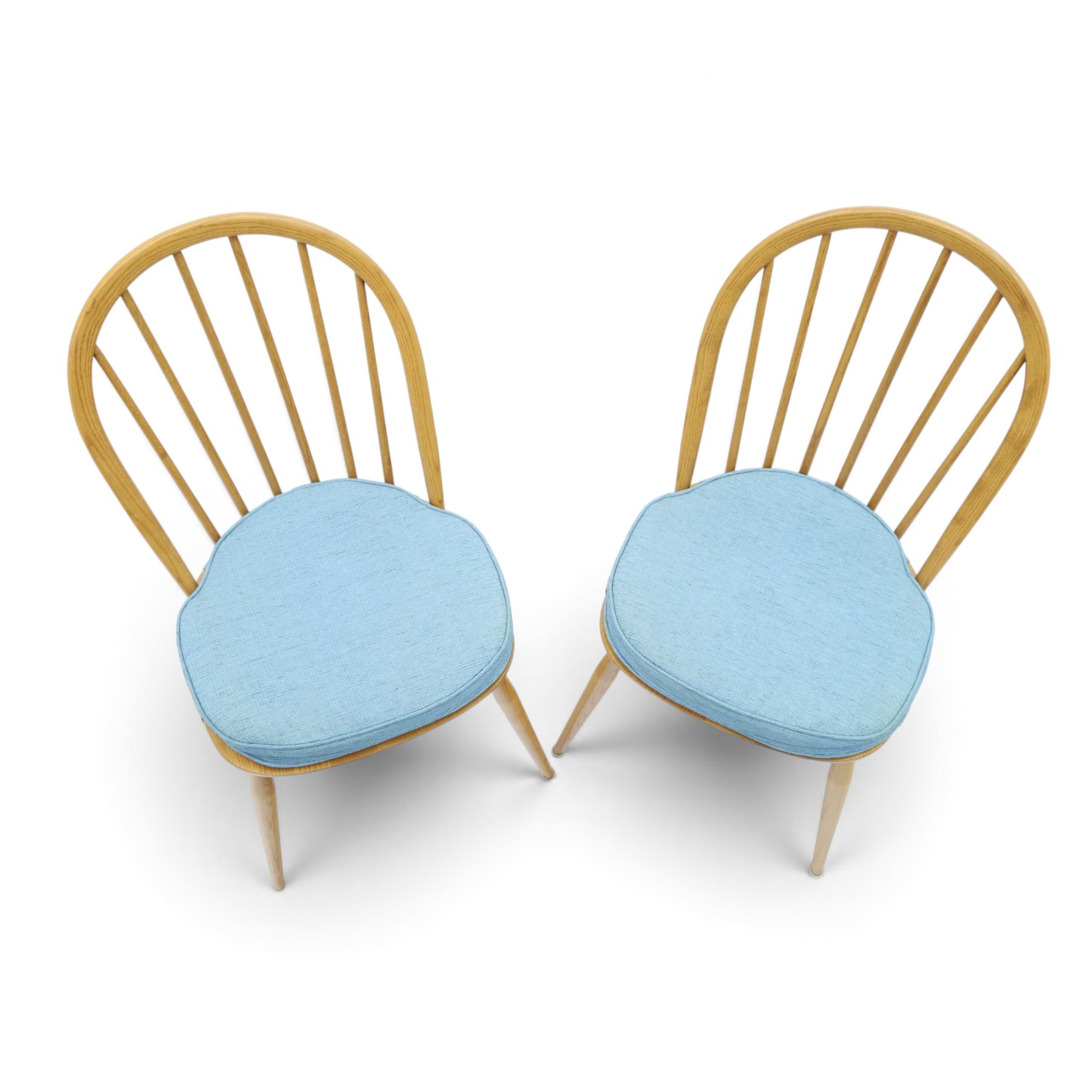 Ercol - pair of 'Windsor' dining chairs, with high hooped back, blue seat cushions with studded, tapered supports  