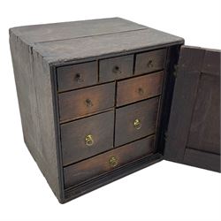 18th century oak spice cupboard, single panelled door enclosing eight drawers of various sizes, reed moulded front edges