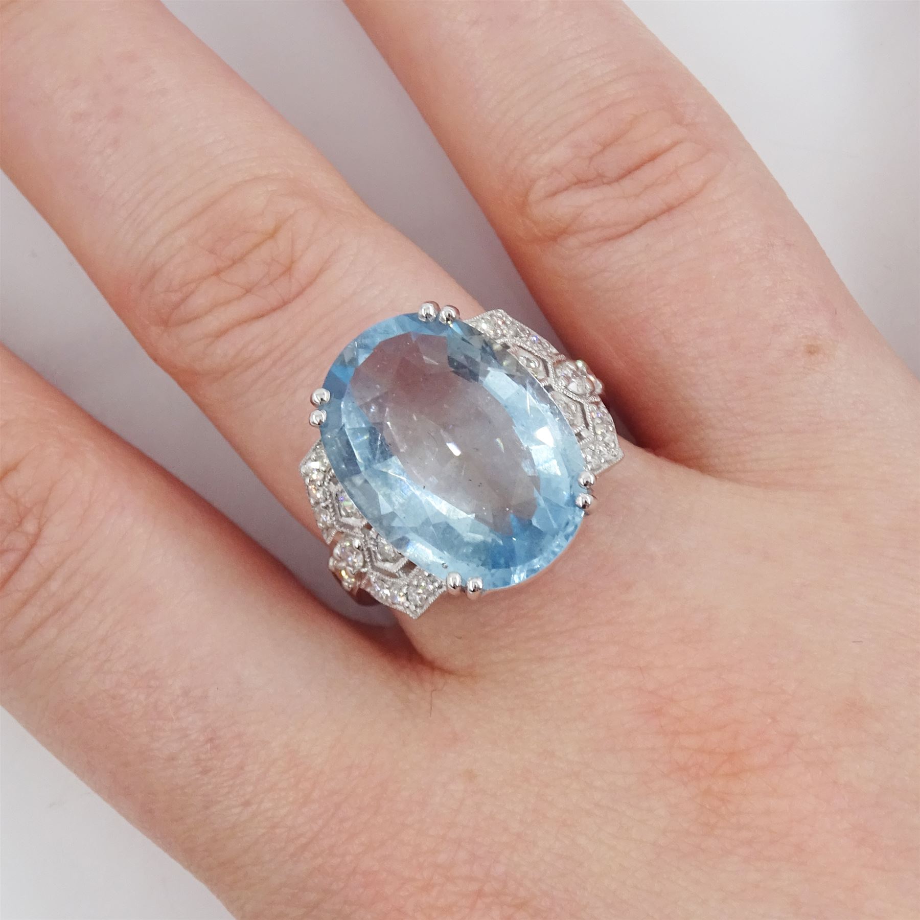 18ct white gold oval cut aquamarine ring, with milgrain set diamond, pierced design shoulders, stamp[ed 750, aquamarine approx 9.65 carat, total diamond weight approx 0.45 carat
