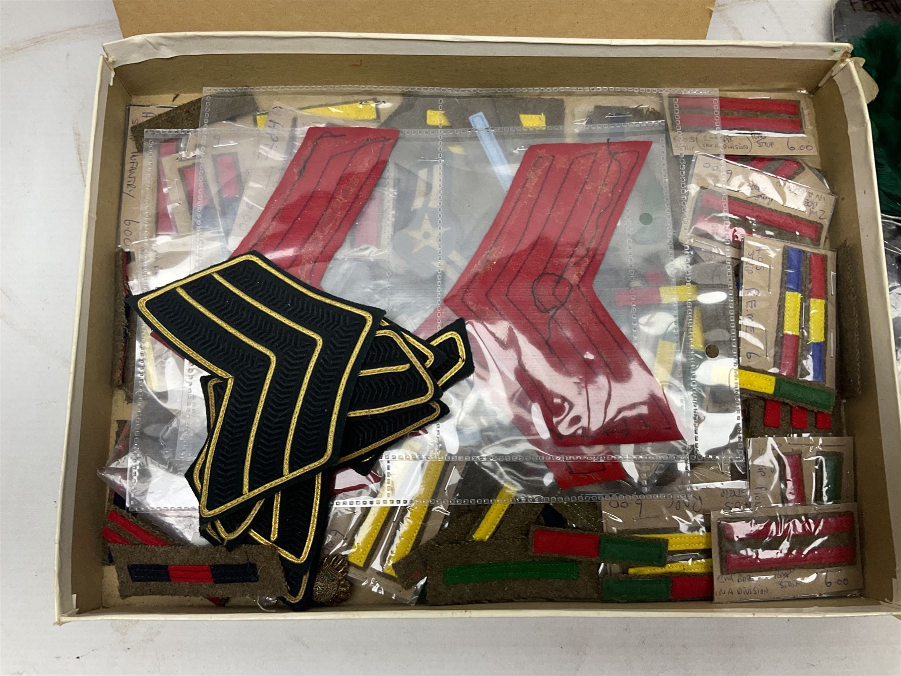 Quantity of military horse hair plumes and feather hackles, cloth stripes and regimental titles etc