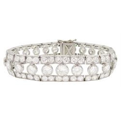 Continental Art Deco platinum old cut diamond openwork bracelet, circa 1920's, twenty-two bezel set graduating diamonds of approx 9.45 carat, the principal diamond approx 0.90, with a row milgrain set diamonds either side, the clasp set with a single diamond, the bracelet sides and clasp with engraved foliate decoration, total diamond weight approx 20.60 carat