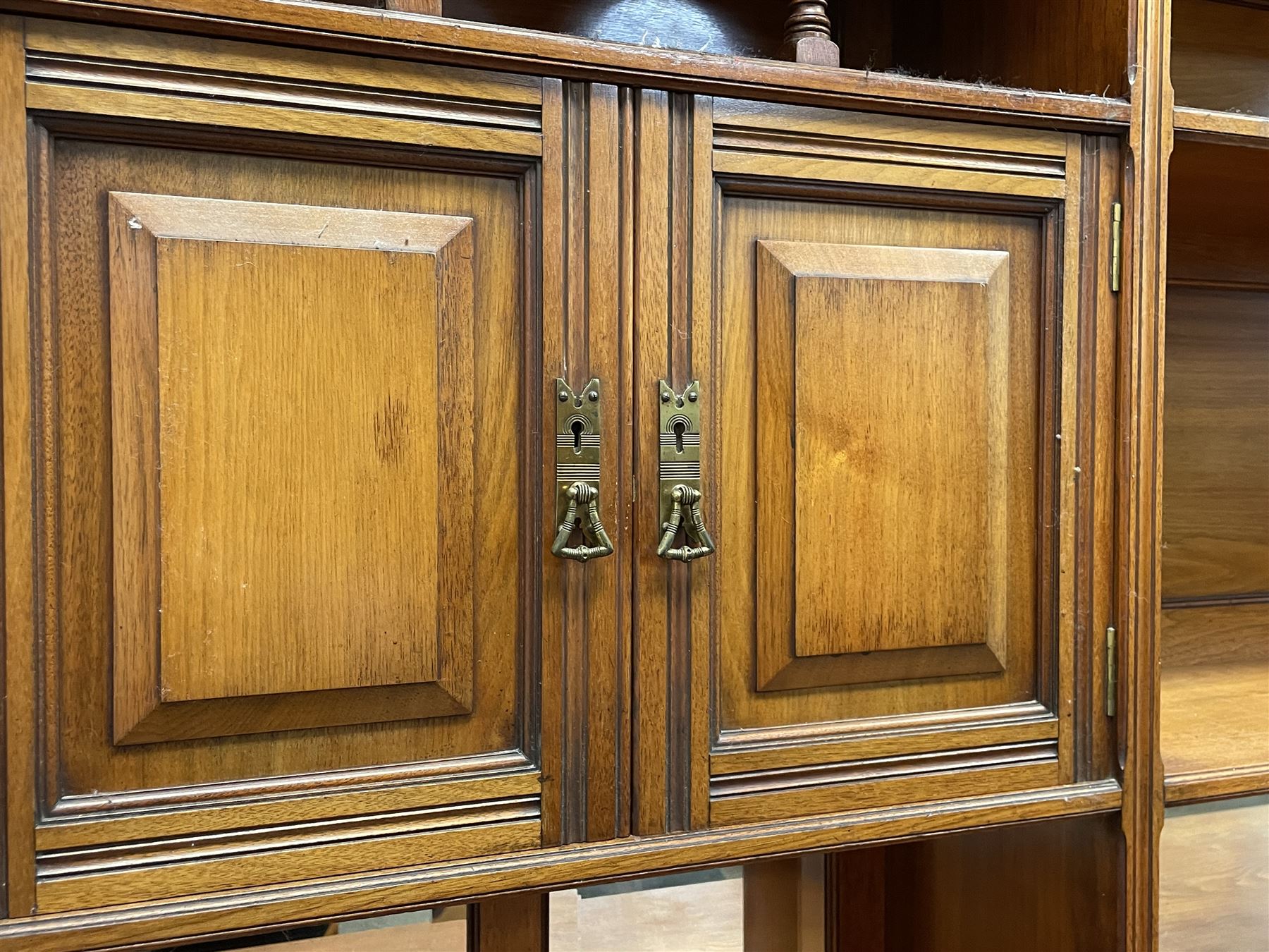 Late Victorian walnut dresser, the raised panelled back fitted with panelled cupboards, shelves and bevelled mirrors, moulded rectangular top over three drawers and cupboards, the left-hand cupboard fitted with two slides and the right-hand cupboard fitted with revolving drinks stand, on turned feet