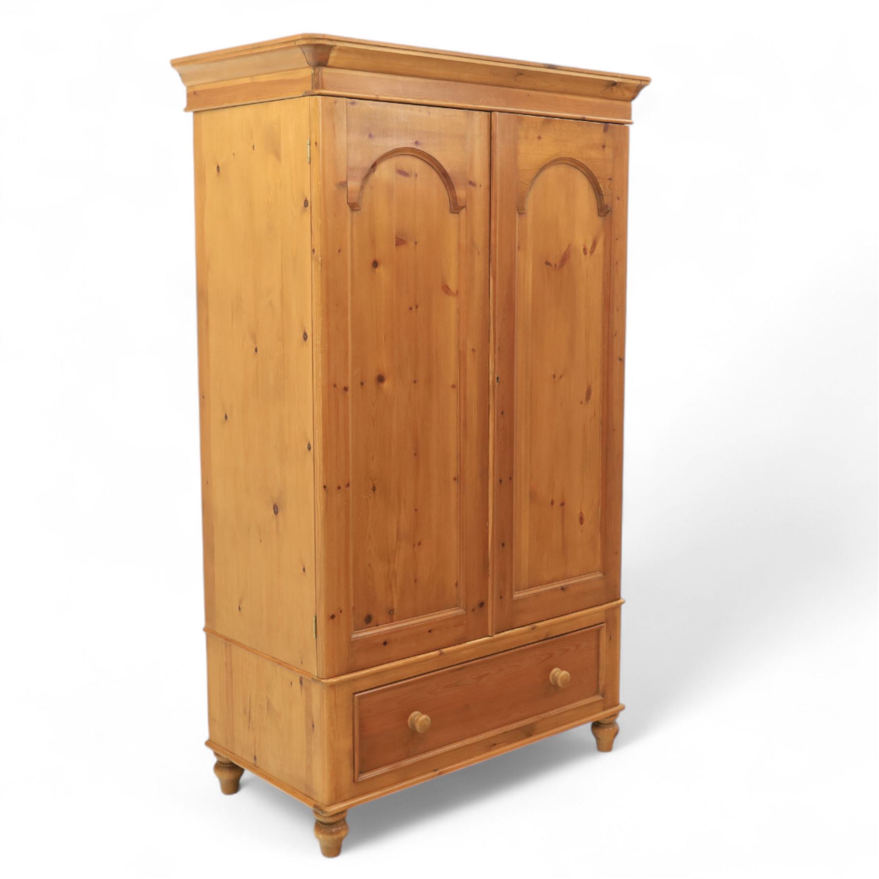 Two contemporary traditional-style wardrobes, projecting plain cornice above two arched moulded panel doors, above a full-width drawer fitted with turned wooden handles, raised on turned bun feet