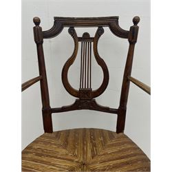 19th century elm elbow chair, shaped and moulded cresting rail over lyre back carved with flower heads, rush seat, on turned supports joined by stretchers