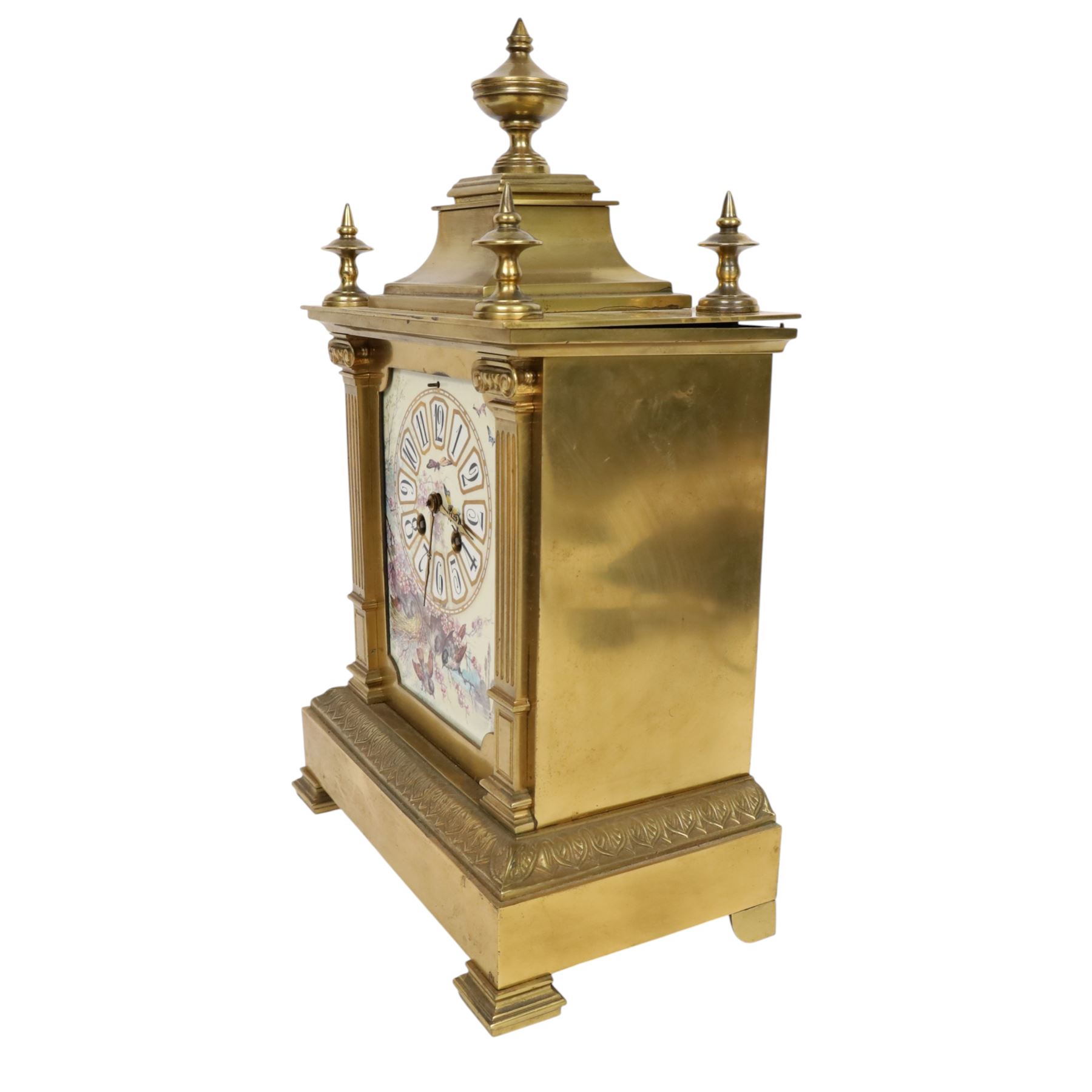 French gilt-bronze and porcelain mantel clock, architectural case surmounted by a stepped pediment with central urn finial and four subsidiary finials above two fluted Corinthian-style pilasters, the entire front inset with shaped porcelain panel incorporating a circular dial and numerals decorated with birds among flowering branches and two winding apertures and pierced brass hands, above a leaf and scroll cast frieze, raised on bracket feet, with an eight-day movement stamped 'AD MOUGIN Deux Medailles' striking the hours and half-hours on a coiled gong, with pendulum, circa 1900
