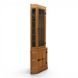 Mouseman - oak floor standing corner cabinet, scalloped cornice above a leaded glass cabin...
