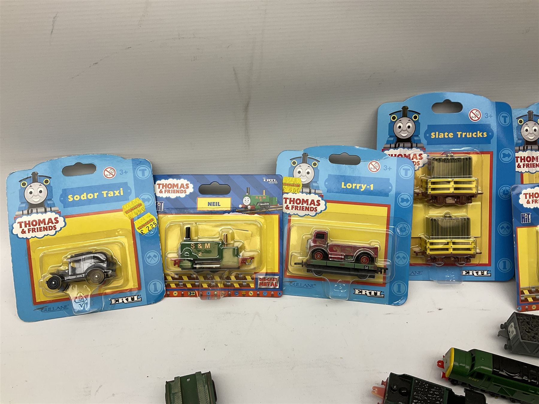 Ertl Thomas the Tank Engine and Friends die-cast models including carded Scrap Trevor, Slate Trucks, Neil, Wilbert, Sodor Taxi, Sodor Recovery Unit, Crane and four key rings; together with various uncarded models including locomotives, coal wagons, steam rollers, boat transporter, recovery units etc (over forty items)