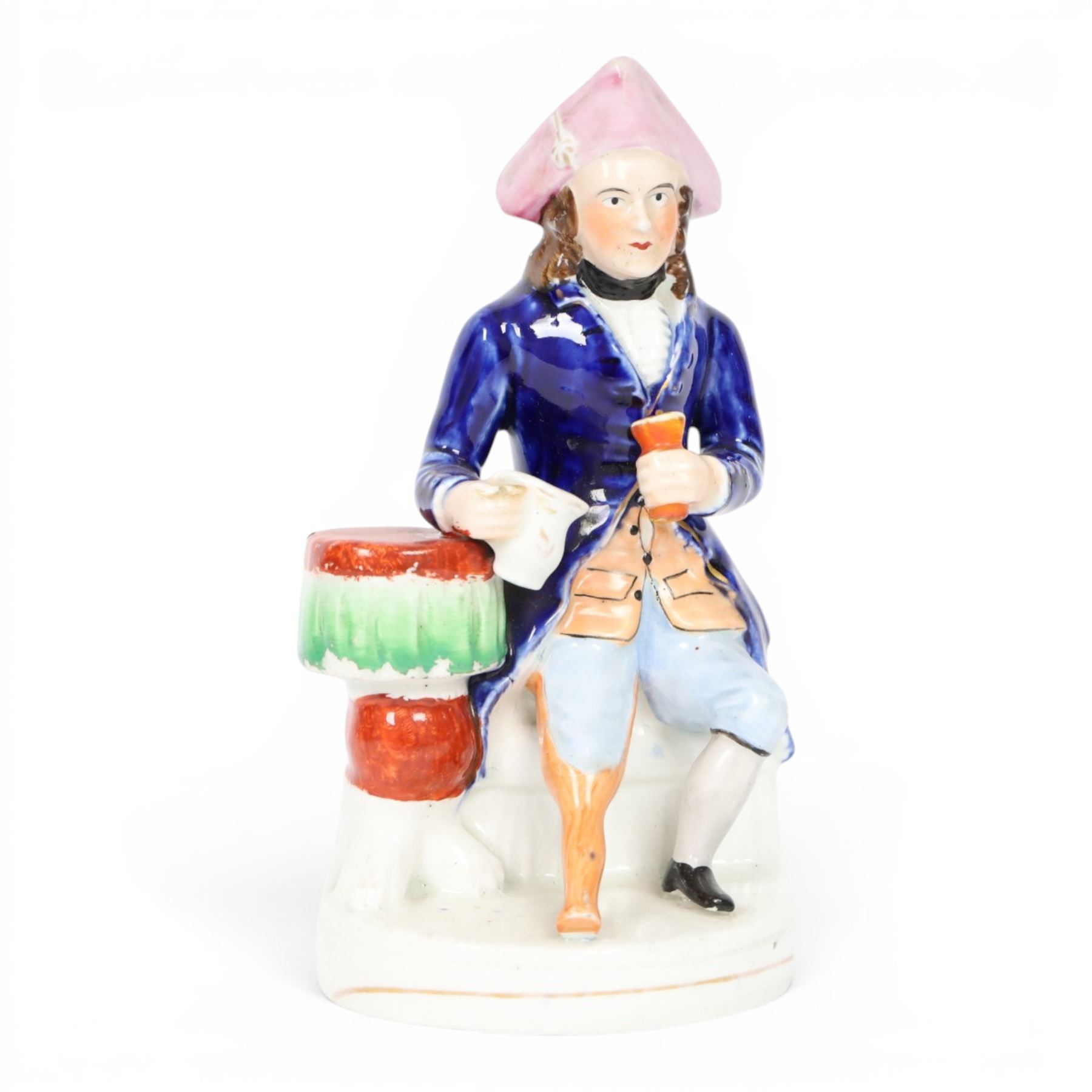 Mid 19th century Staffordshire figure of a Greenwich Hospital pensioner, circa 1850, modelled as a seated sailor with a peg leg, his left arm holding a goblet, his right leaning upon a table and holding a jug, wearing naval uniform and tricorn hat, H21cm
