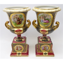  Pair of late 19th Century Vienna style porcelain campana urn shaped vase on stands, decorated with 18th century style panels after Angelica Kauffman, H40cm (one A/F)  