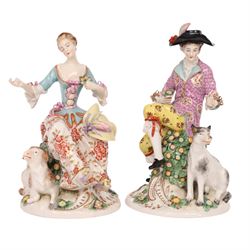 Pair of 19th century Samson figures, the gentleman wearing a wide brimmed hat with a dog, the lady with a sheep by her side, both figures seated upon a floral encrusted pillars with gilt scrolling base, H22cm