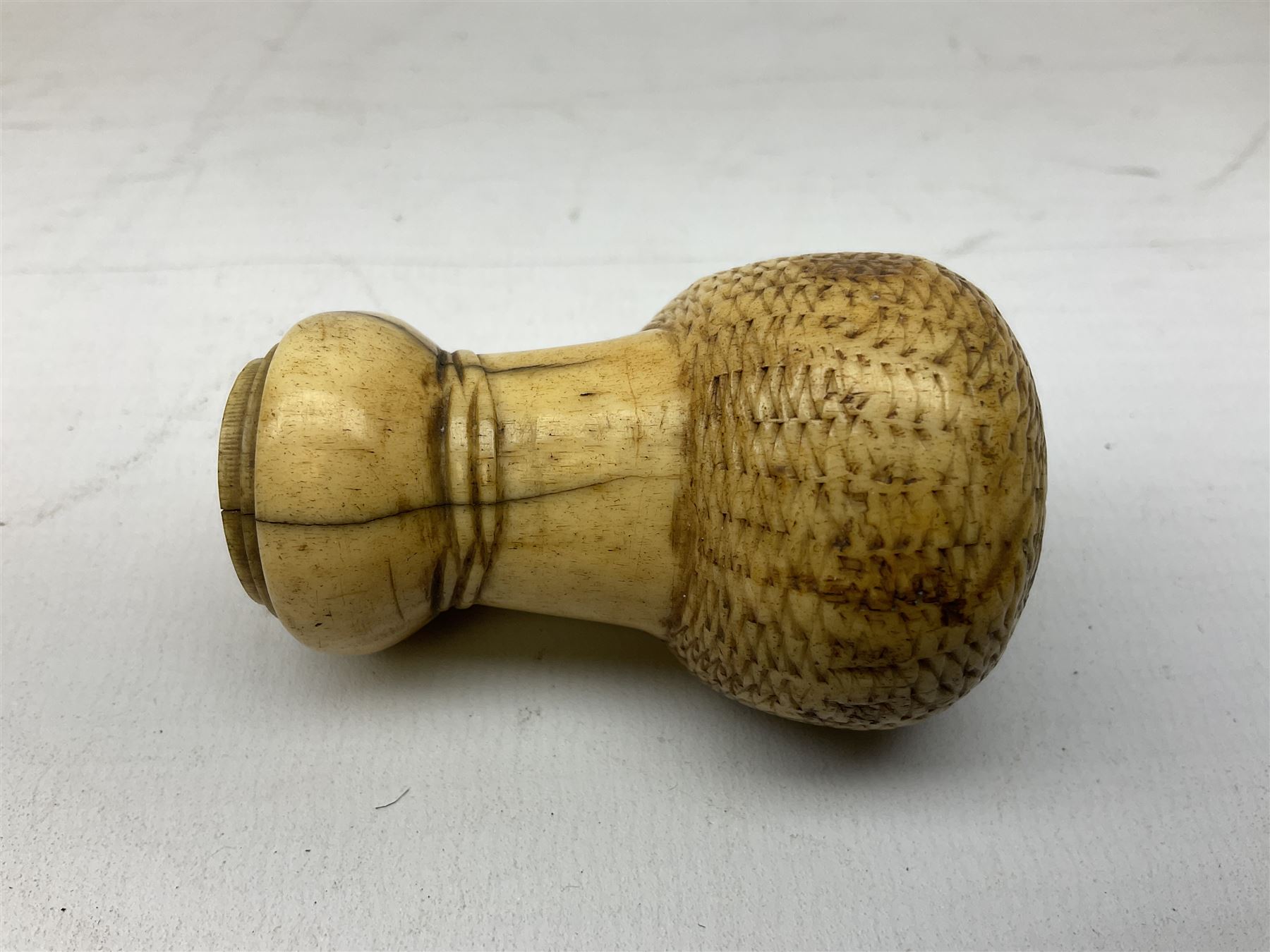 19th century carved ivory walking cane handle, modelled as the head of a greyhound with inset glass eyes, together with a further 19th century ivory example, modelled as a caricature of a gentleman's head, (2)