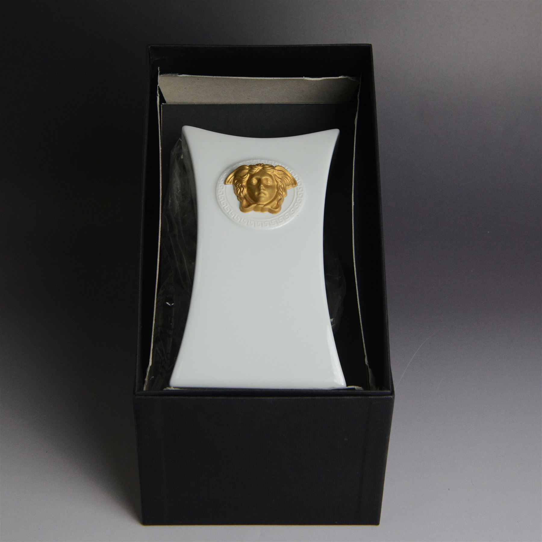 Rosenthal Versace Gorgona vase, of concave form, decorated in relief with medusa masks and gilt greek key borders upon a white ground, boxed, H17cm
