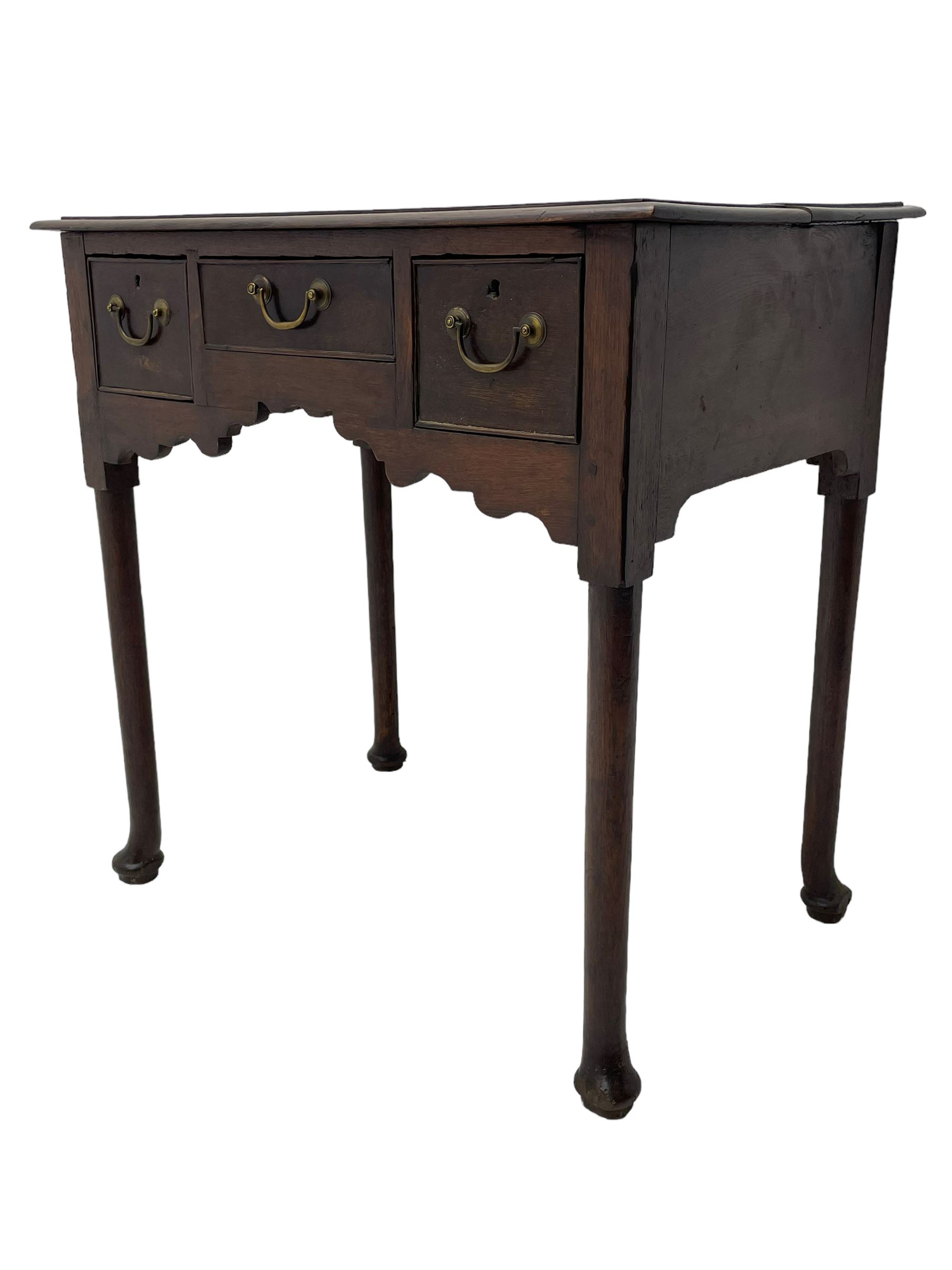 18th century oak low-boy, ovolo-moulded rectangular top over three cock-beaded drawers, circular brass handle plates and D-shaped handles, shaped and stepped arched apron, on cabriole supports 