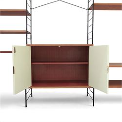 WHB - 'Ladderax' 1960s German modular shelving wall unit, comprising two teak cabinets with white doors, a further fall front teak cabinet with white front, a drawer section with three drawers with recessed handles, multiple shelving sections, raised on metal ladder frames, with further spare sections

Cabinet units: H 47cm, D 36cm, W 71cm
Fall front unit: H 40cm, D 26cm, W 71cm
Shelve widths: 50cm, 71cm 
Shelve depths: 26cm, 36cm