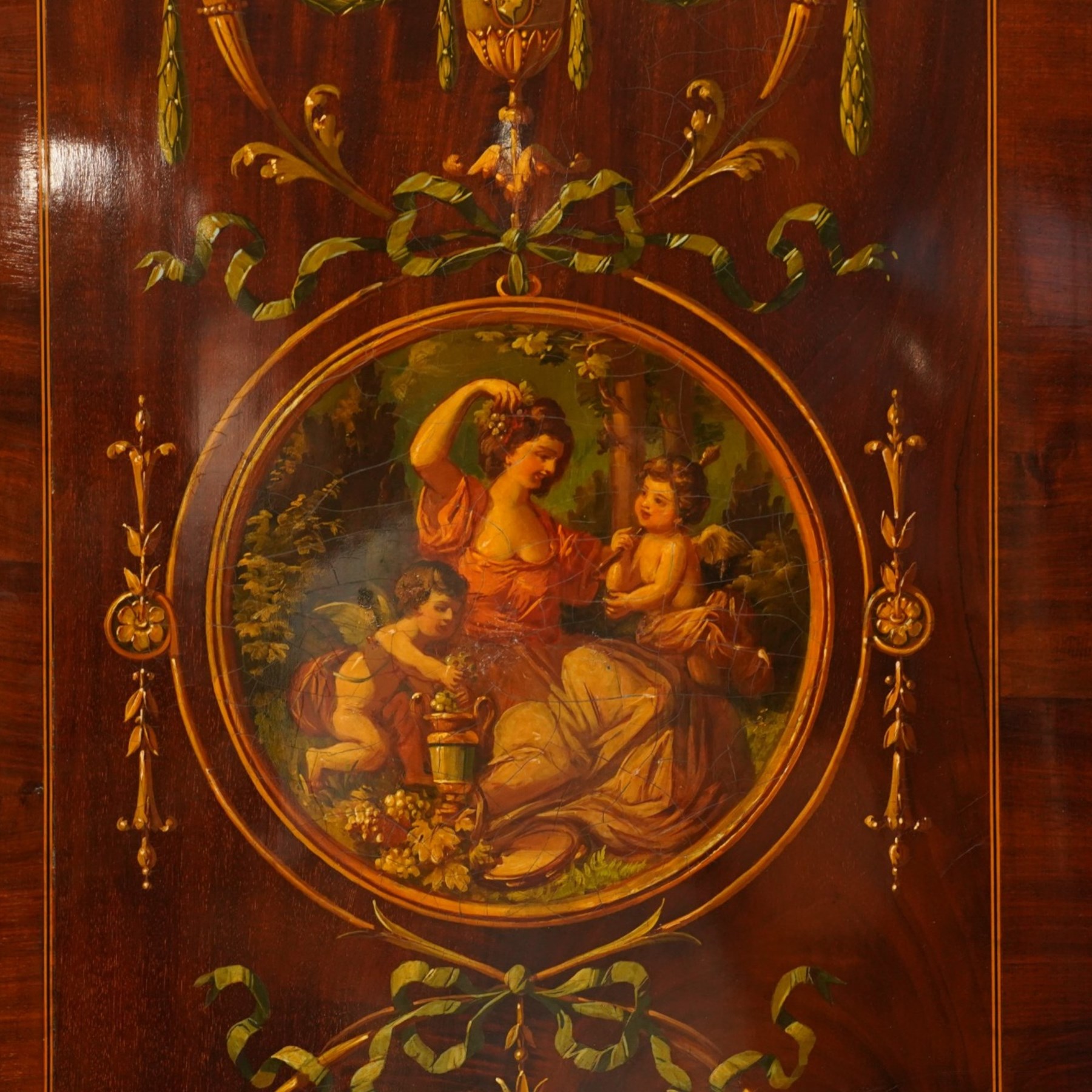 19th century French Louis XVI design mahogany and polychrome painted gentleman's press wardrobe - projecting cavetto cornice with urn and bellflower painted frieze, the twin doors with classical figural medallions surmounted by urns and festoon decoration with scrolling acanthus leaves, enclosing five sliding trays, the base fitted with two short over three long cock-beaded drawers, the facias painted with interlocking swags and garlands of bouquets with recumbent lion brass handle-plates, lower reeded edge on turned feet