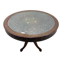 Pakistan carved hardwood brass inlaid circular dining table, and four rail back chairs with saddle seats