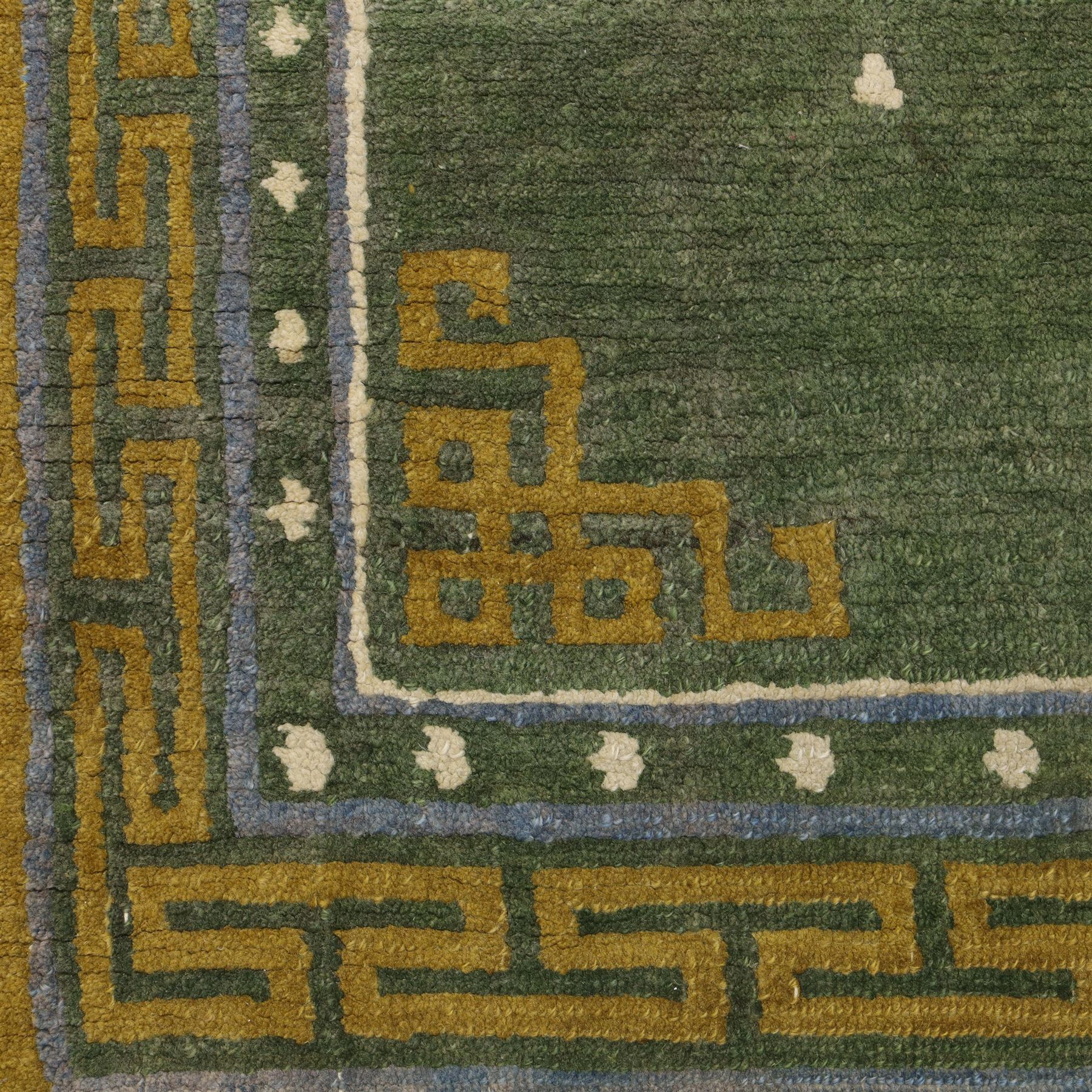 Chinese Ningxia rug, green field with central stylized shou medallion and scattered cloud motifs within key fret borders in shades of olive green, fringe ends partially detached 