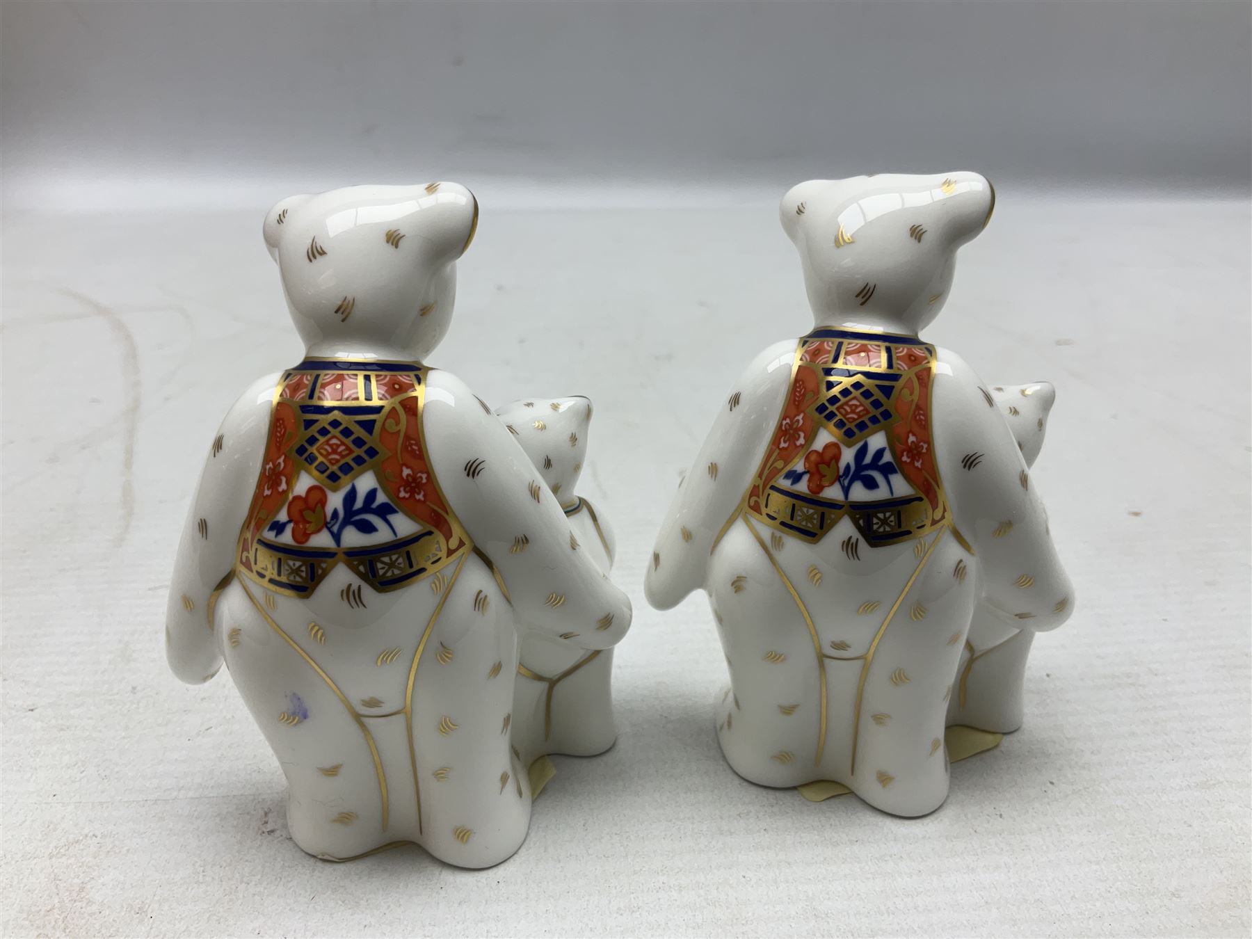 Four Royal Crown Derby teddy paperweights, comprising Teddy Cook, two Teddy George and Seated Teddy, all without stoppers, together with Crown Namestake with gold stopper 