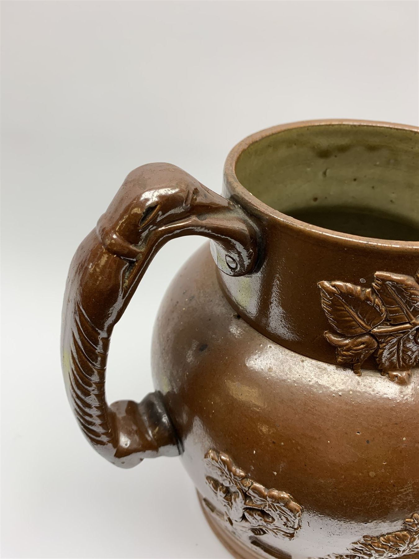 19th century salt glazed stoneware jug, with mask spout and greyhound modelled handle, the body decorated in relief with Royal Coat of Arms flanked by lions, the rim with the flowers of the union, roses, thistles and shamrocks, H26.5cm