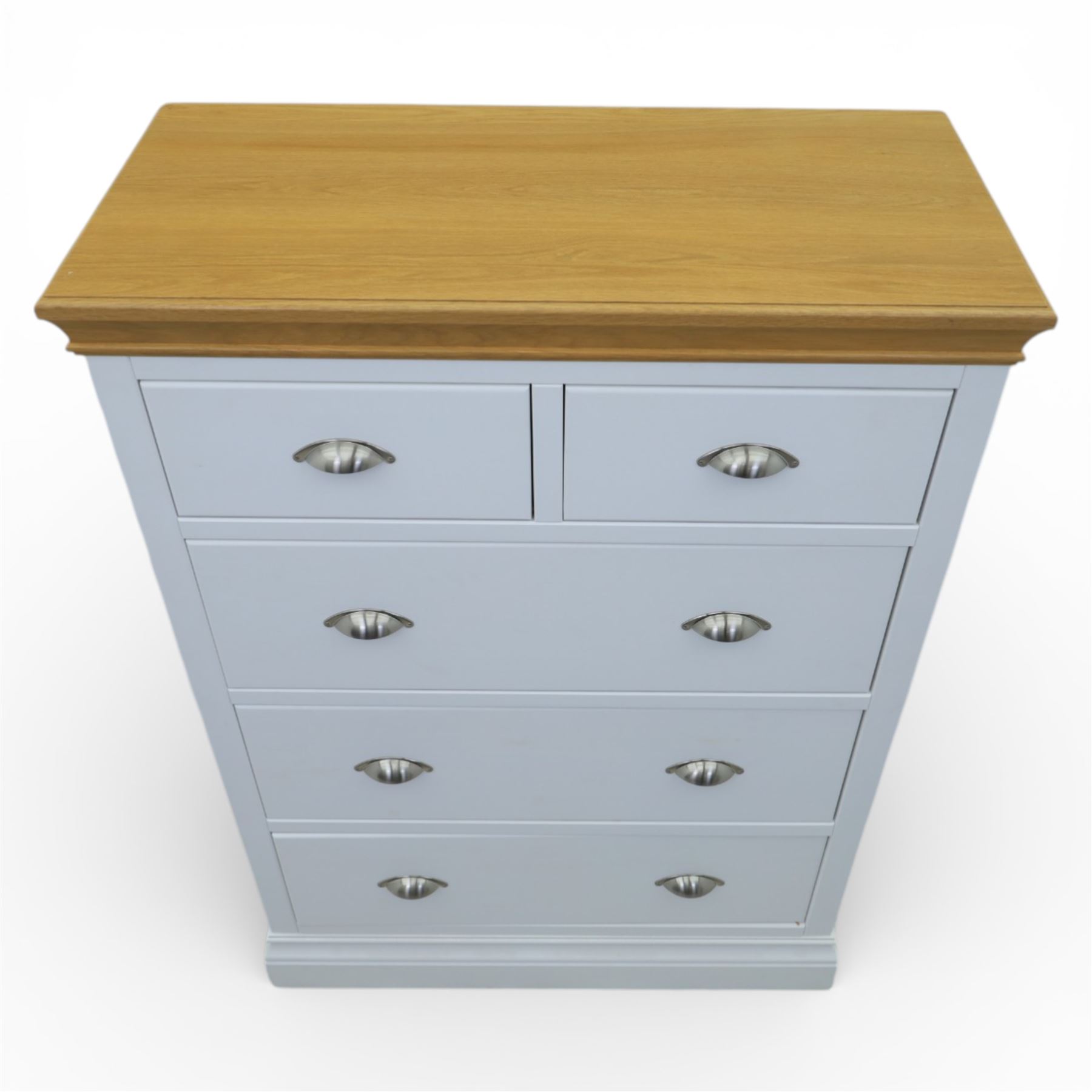 Modern chest of two short and three long drawers in white finish with oak moulded top, with metal cup handles, raised on a moulded plinth base