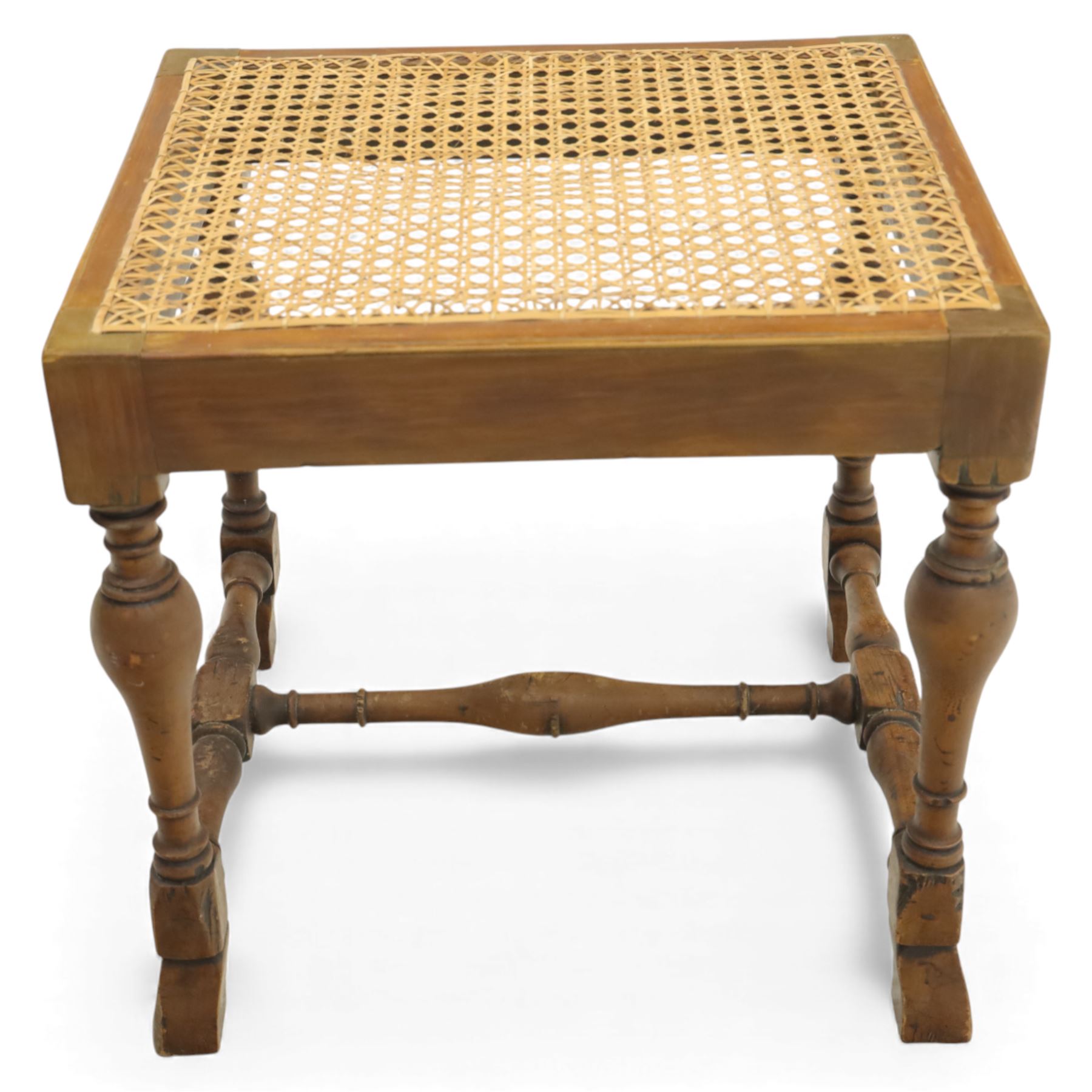 Two upholstered and caned footstools, a late Victorian carved mahogany footstool, oval form upholstered in geometric kilim-style fabric, on cabriole supports (H 27cm, W 56cm, D 47cm), together with a 20th century beech stool, square caned seat on turned supports united by stretchers (H 43cm, W 44cm, D 37cm)