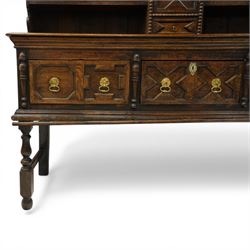 19th century Jacobean Revival oak dresser and rack, the upper section with open shelves and central cupboard, flanked by bobbin moulded uprights, the base fitted with three carved drawers with brass ring handles, raised on turned supports united by stretchers