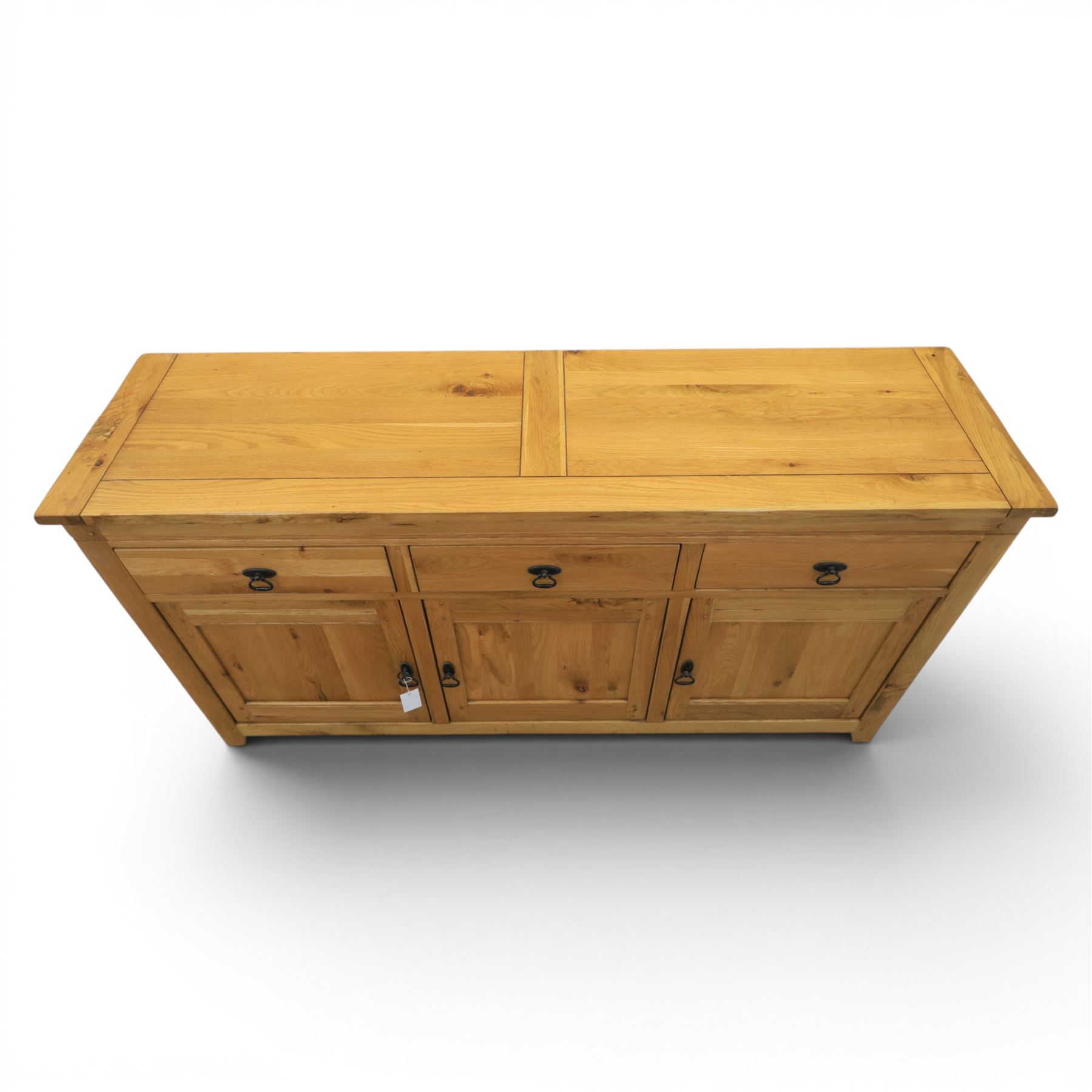 Contemporary oak sideboard, with rectangular top above three drawers and three cupboard doors, blackened metal handles, raised on stile supports