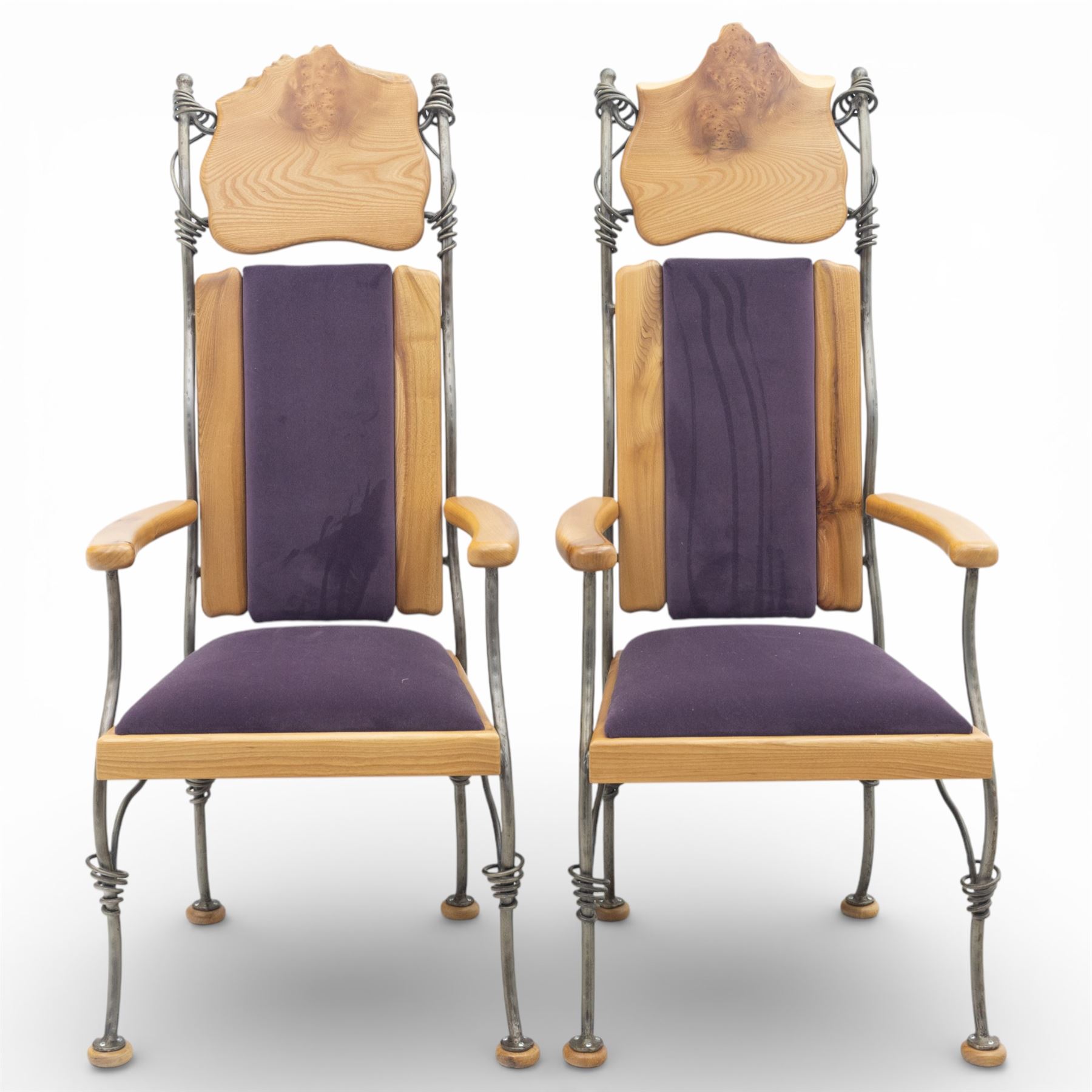 Paul Hodgkiss Designs of Glasgow - contemporary shaped elm dining table with wrought iron base; with set ten (8+2) matching high-back dining chairs, table of organic form above an elaborate wrought iron supports, with central elm stretcher, the chairs with en suite with matching wrought iron work burred elm headrest, purple velour upholstery with drop in seat     

Table: W 102cm, L 243cm, H 74cm
Chairs: W 56cm, D 52cm, H 130cm