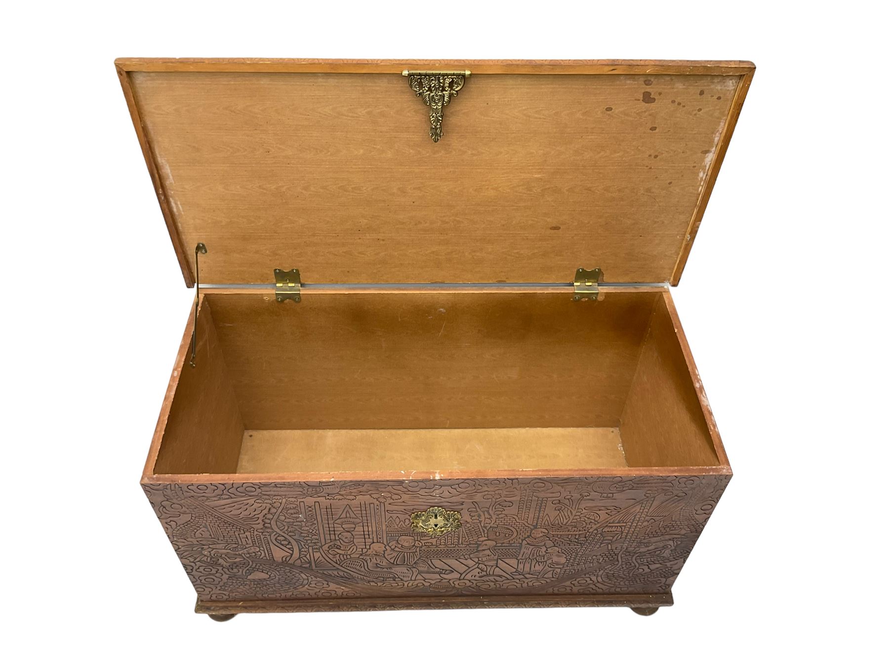 Hong Kong camphor wood chest, rectangular hinged top, carved all over with traditional scenes and dragon boats, on bun feet