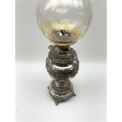 A Victorian silver plated oil lamp, of baluster form upon four scroll feet, decorated with presentation inscription within a repousse foliate and scroll surround, the collar marked Evered & Company Ltd patent safety lock collar, supporting a frosted glass shade, overall H54cm. 