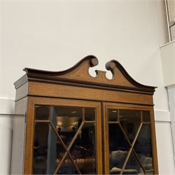 19th century walnut and  satinwood inlaid bookcase on bureau, broken swan neck pediment over two astragal glazed doors, inlaid throughout with fretwork panels depicting scrolling foliage, fall front enclosed drawers, small cupboard and inset leather writing surface, leather inset slide over two short and three long drawers, on bracket feet