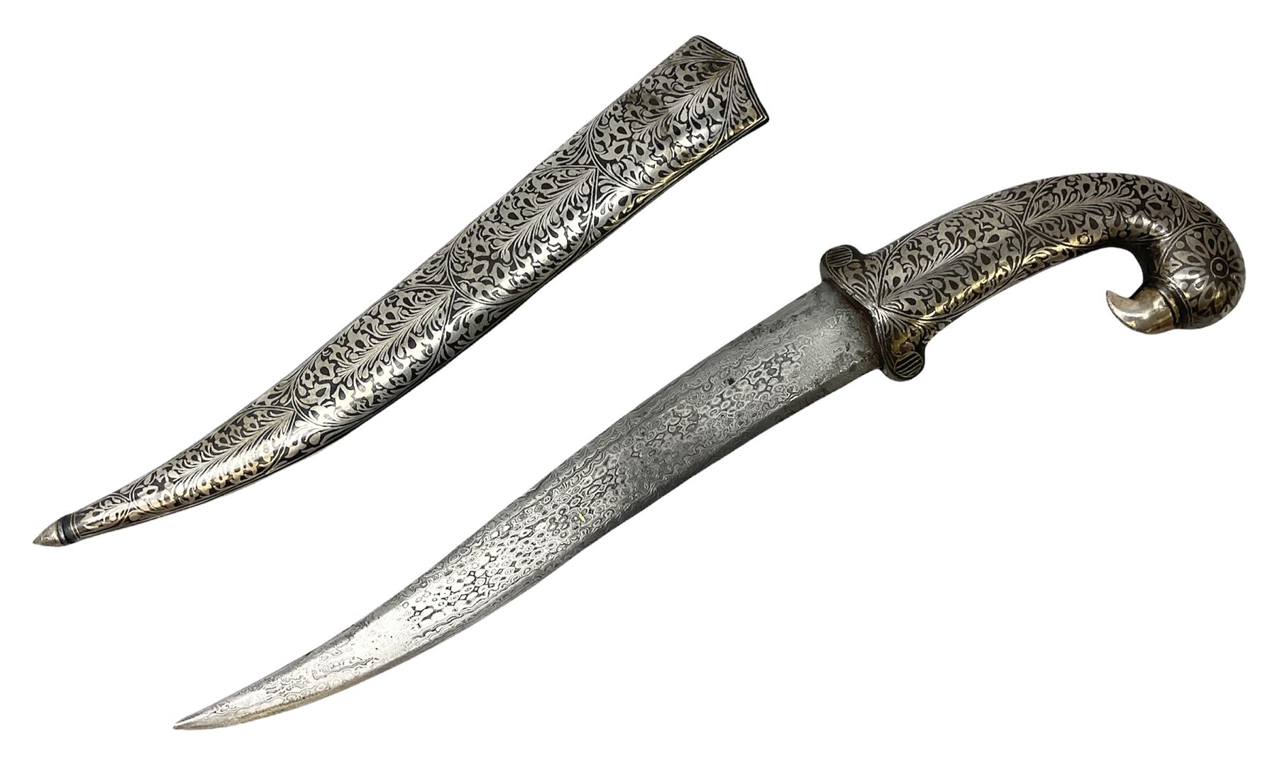 Indian Khanjar dagger with 28cm curving damascus steel blade inlaid with silver floral emblem, white metal and niello style grip in the form of a bird's head with pronounced beak and matching scabbard L44cm overall