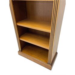 Georgian design walnut open bookcase, projecting cornice over figured banded frieze flanked by roundels, fitted with six adjustable shelves with flanking fluted uprights, on skirted base