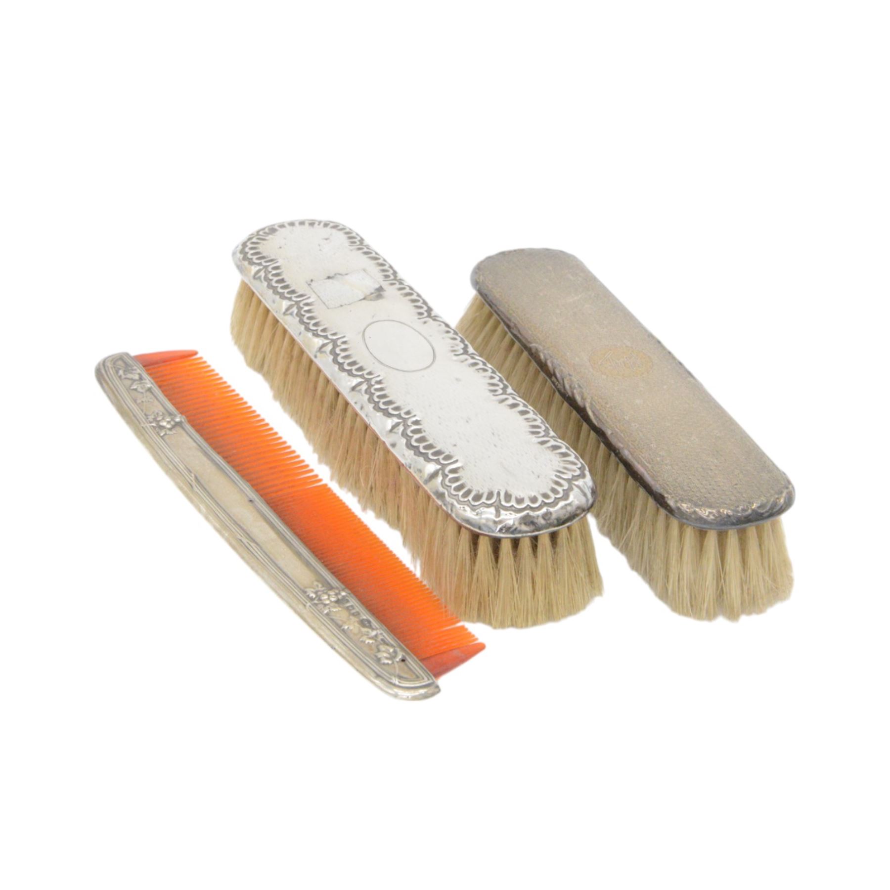 Group of silver mounted dressing table items, to include dwarf candlestick, with embossed ribbon decoration, comb holder, jar lid and six clothes brushes, all hallmarked 