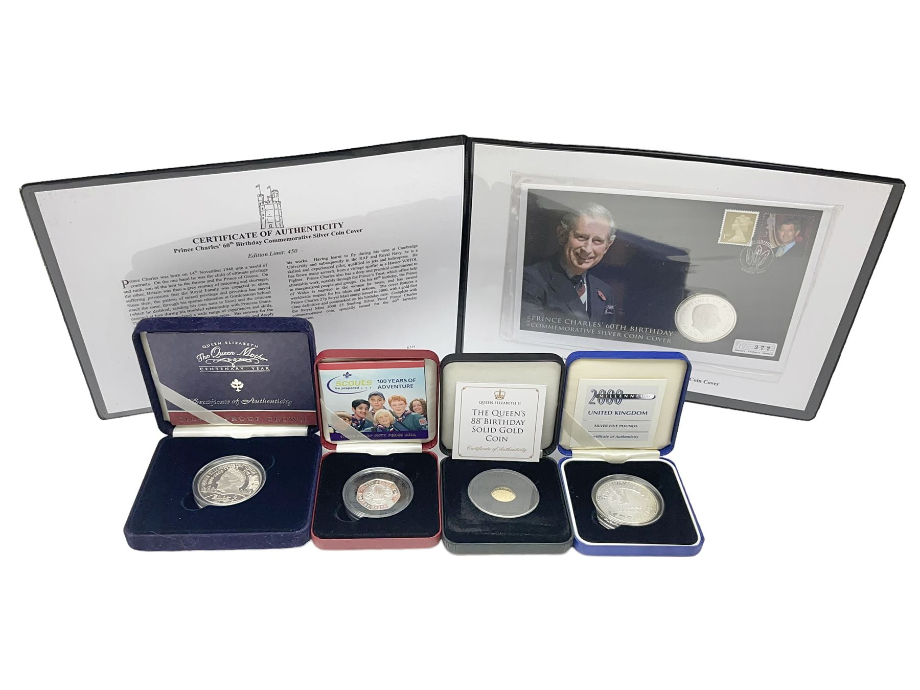 Queen Elizabeth II 2000 'The Queen Mother' silver proof five pound coin, 2000 'Millennium' silver proof five pounds, 2007 'Scouts' silver proof fifty pence, Tristan Da Cunha 2014 9ct gold 1 gram gold one crown coin, all cased with certificates and a 'Prince Charles 60th Birthday Commemorative Coin Cover' containing a 2008 silver proof five pound coin in folder (5)
