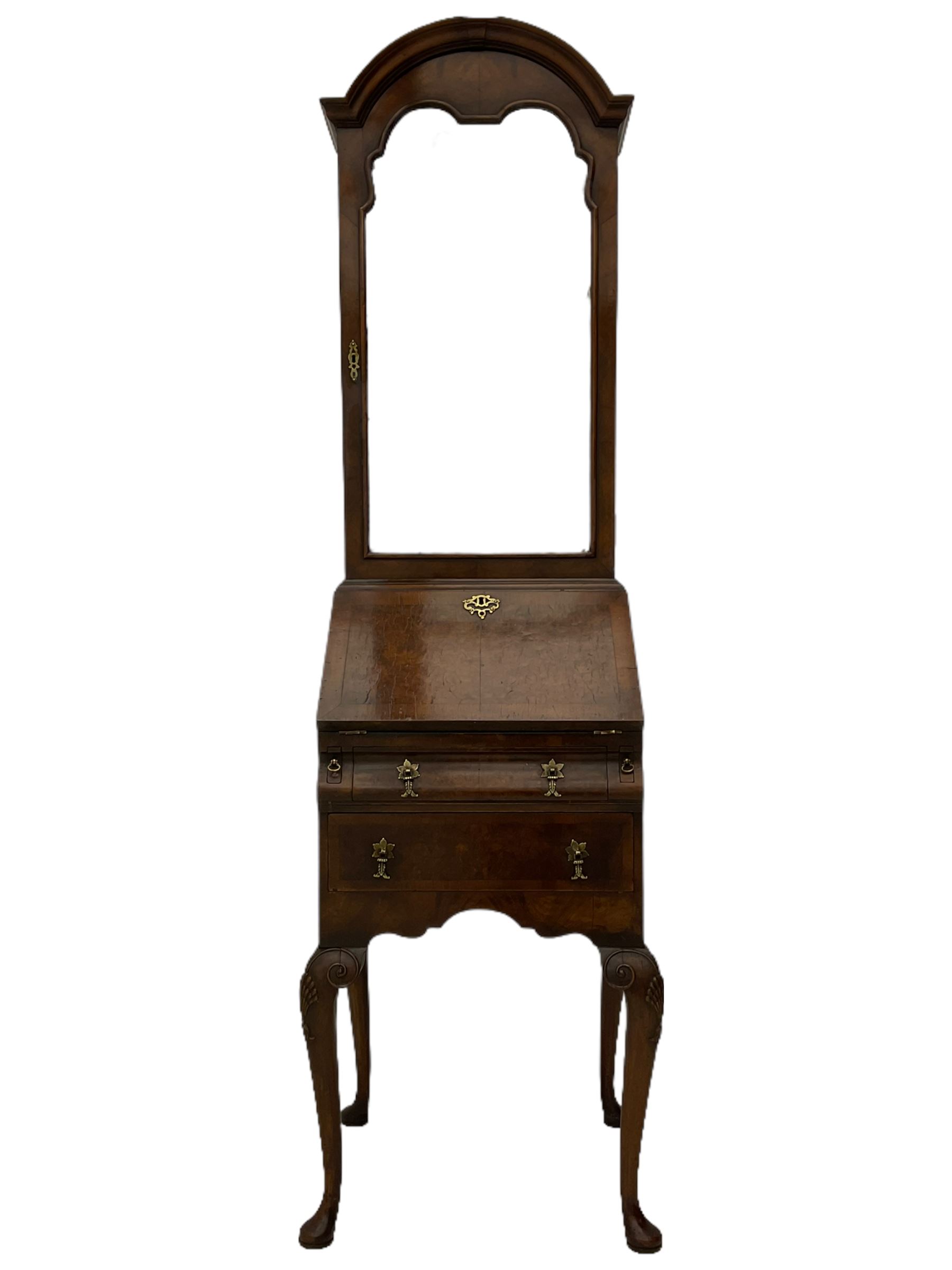 Small early 20th century Queen Anne style bookcase on bureau secretaire, the moulded arched pediment over mirrored door in shaped frame, the bureau fitted with fall front enclosing curved fitted interior, cushion moulded drawer over single drawer, on scroll and shell carved cabriole supports