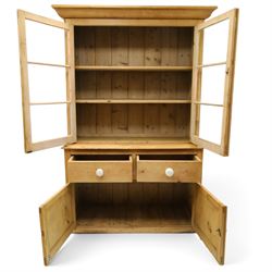 Victorian stripped pine and glazed dresser, projecting ovolo cornice over glazed doors enclosing two shelves, the base fitted with two drawers over panelled cupboards with ceramic handles, on moulded skirted base