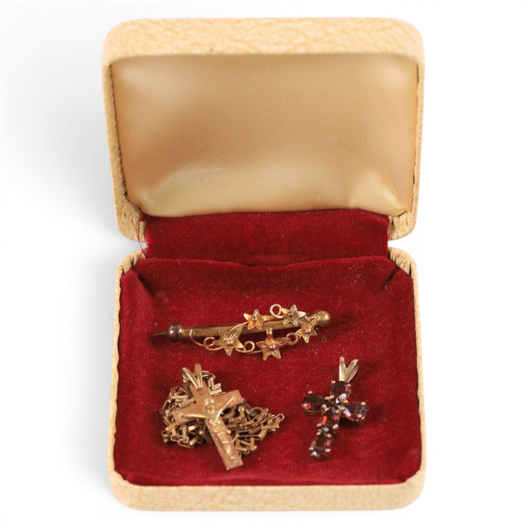 9ct jewellery, comprising stone set cross pendant, crucifix pendant on gold chain and a vine brooch, all stamped or hallmarked