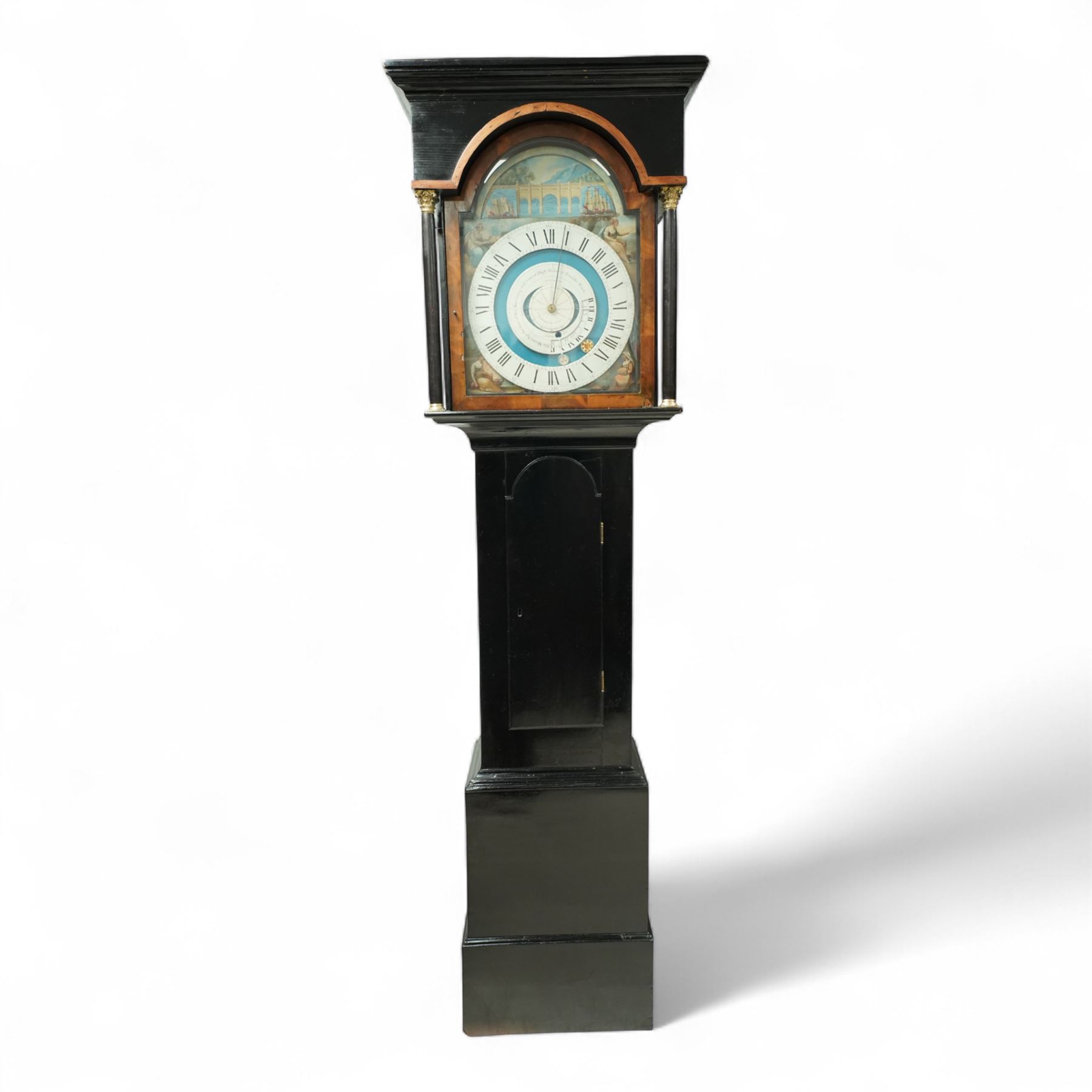 Thomas Emberson of Long Sutton (Lincolnshire) - Early 19th century longcase clock c1810 with a 30hr movement and an exceptionally rare 24-hour painted dial, housed in an ebonised Pine case with a flat pediment and break arch hood door, glazed side panels and turned pilasters with brass Corinthian capitals, trunk with a long door and conforming break arched top raised on a stepped plinth, fully painted dial with painted spandrels representing the four seasons and an operating automata depiction of ships at sea, rising and falling with the time of high and low water to the arch, with a 24-hour chapter with Roman numerals, five minute Arabic's, minute and inner quarter hour tracks, steel radial minute hand and image of the sun recording the hours, secondary inner dial illustrating the phases of the moon and lunar calendar recording the date and times of high and low water at Fosdike Wash (Lincolnshire), with an adjustable circular disc to the centre giving the times of high water at seven other locations including the Northern Pacific Ocean, dial attached to a countwheel striking chain driven movement, sounding the hours on a bell. With weight and pendulum.
Thomas Emberson is recorded not as a clockmaker but a machine maker from Long Sutton. This clock is also thought to have originally contained a musical movement, now removed, and was clearly an individual project possibly based on an earlier clock by John Ferguson illustrated in 