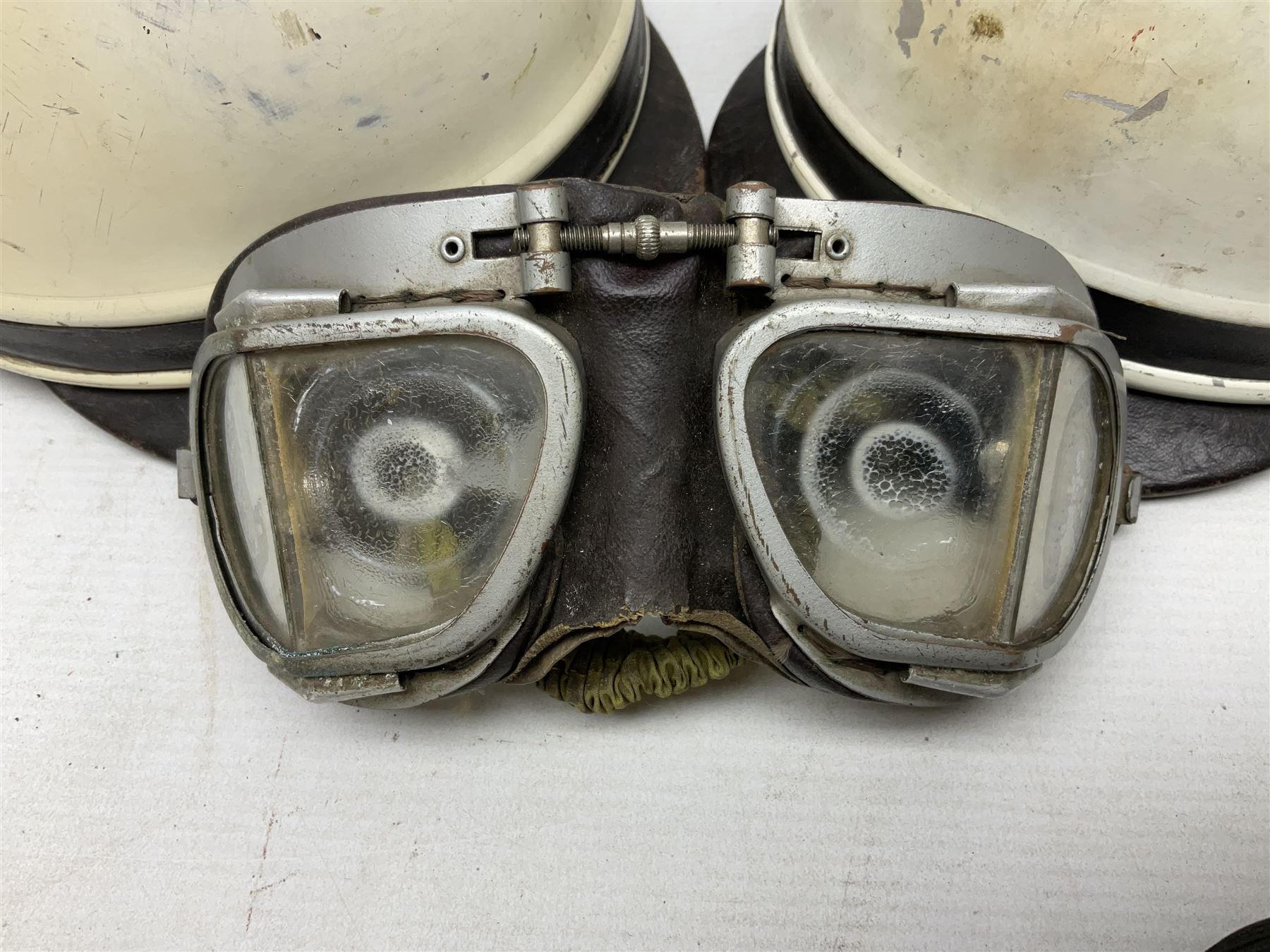 Two Geno Paris small size motorcycle helmets; and three pairs of goggles, one marked 'Stadium'
