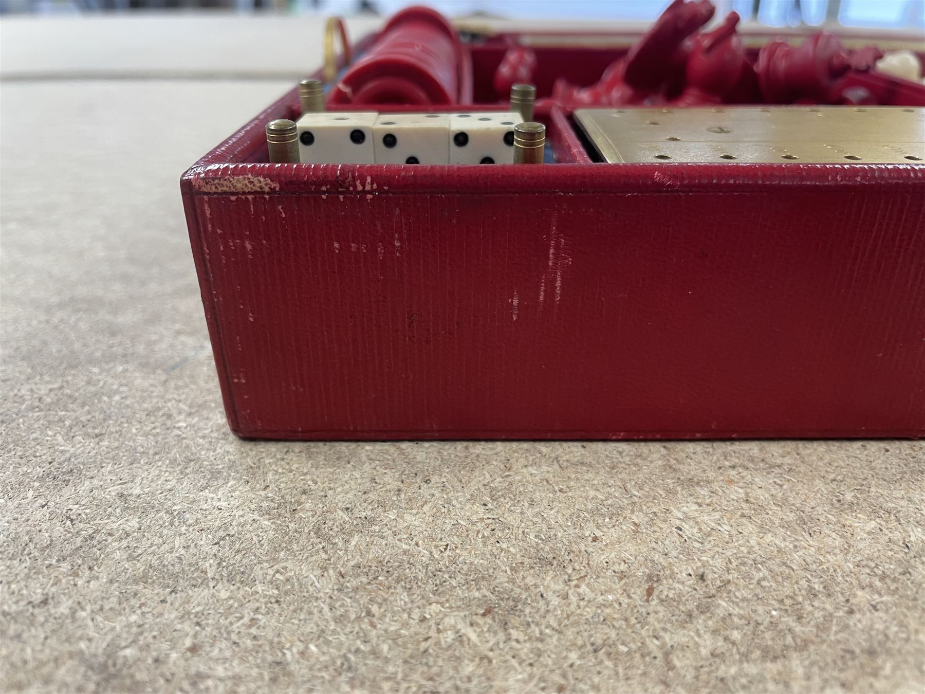 19th century walnut and brass bound games compendium box, painted to enhance the grain, of rectangular form, the hinged opening cover with rounded sides, central brass cartouche with engraved lion crest, and brass riveted straps, opening to reveal a red leather and blue silk lined compartmented interior, with fold-down games board, and lift-out tray containing playing cards, ebony turned dice towers, white and red stained bone draughts, and chess pieces, ivory dice, and ivory and ebony whist markers, and brass bezique board, cribbage board and markers, H15cm W32cm D24cm
This lot has been registered for sale under Section 10 of the APHA Ivory Act