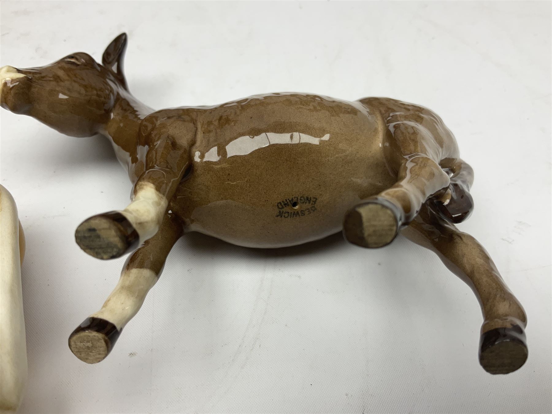 Four Beswick horse figures, comprising Quarter Horse, two Shires no 818 and matt palomino, together with Beswick donkey and Royal Doulton horse on a wooden plinth  