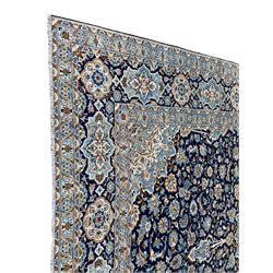Persian indigo ground rug, the pale blue pole medallion within a field surrounded by scrolling floral decoration with matching spandrels, the thick guarded border with repeating stylised plant motifs within geometric shapes