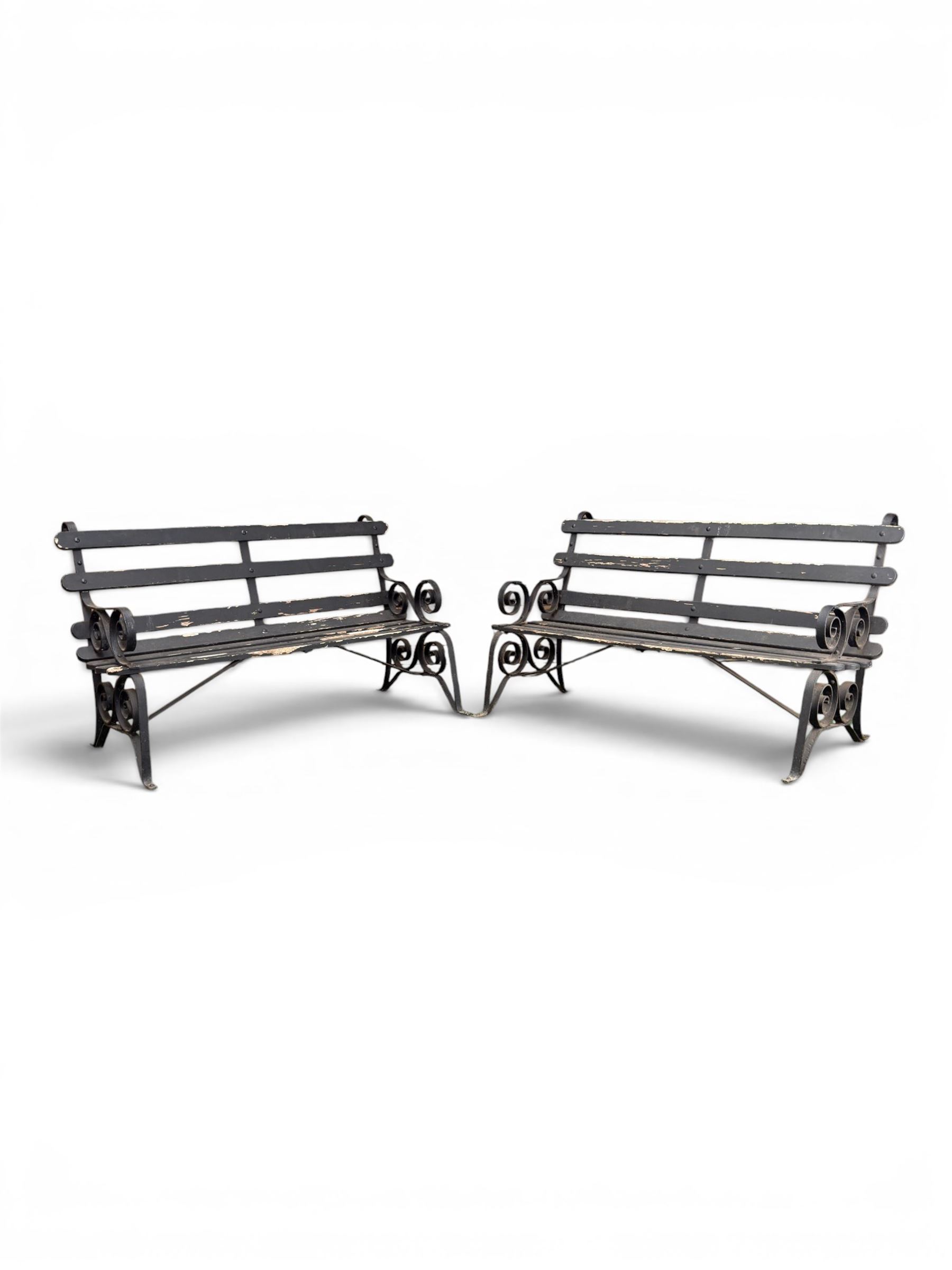 Coalbrookdale - rare pair of wrought iron and slatted wood garden benches, the twin wrought iron strapwork bench-ends formed of four scrolls over splayed feet, number 77 in the Coalbrookdale Castings Catalogue (see illustration)