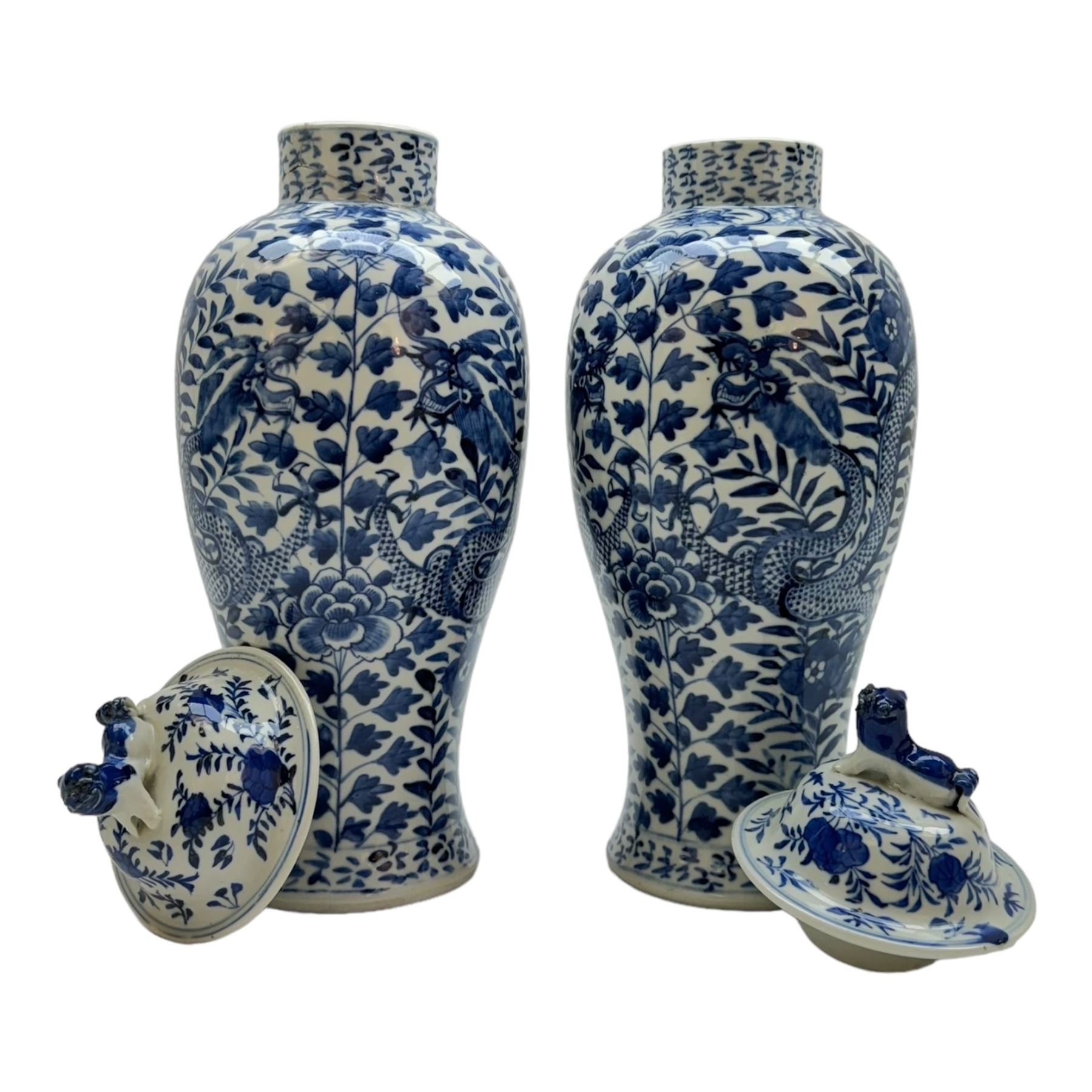 Pair of Chinese vases and covers, of baluster form the blue and white design depicting dragons in foliage, with character marks beneath, H38cm